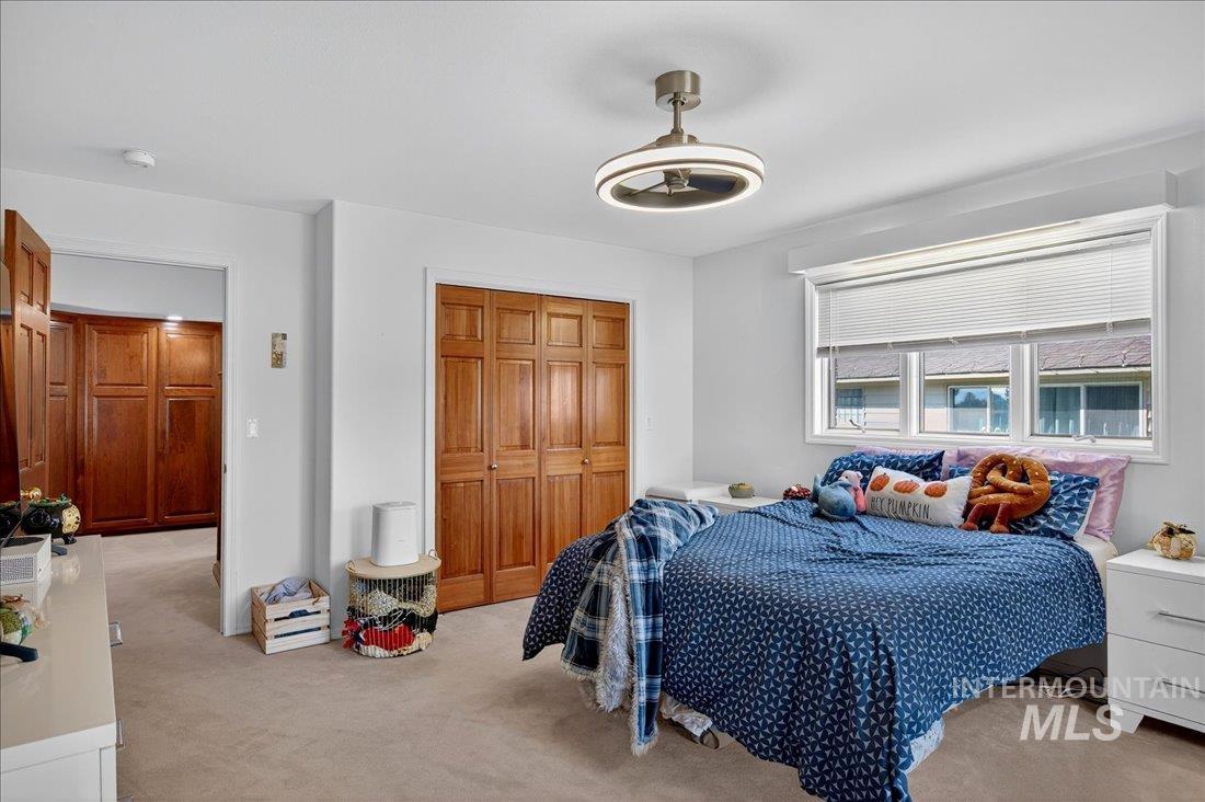 Bedroom featuring carpet flooring, a closet, and ceiling fan