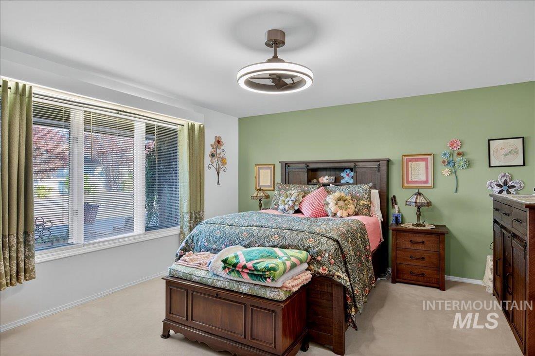 Bedroom featuring light carpet and baseboards