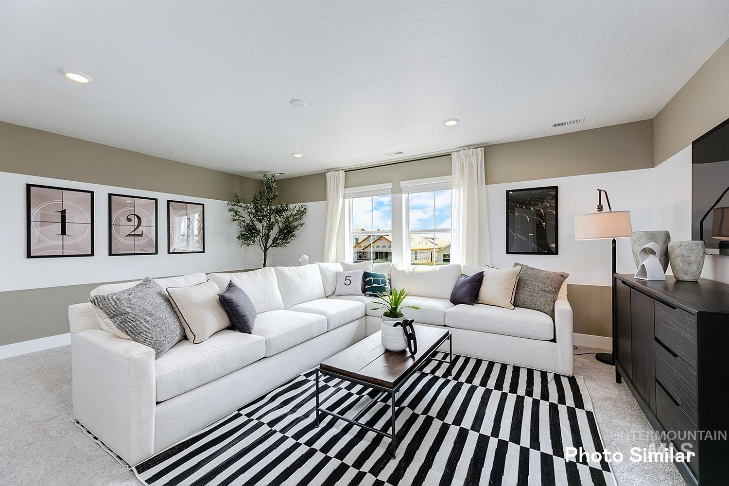 Living area with light carpet and recessed lighting