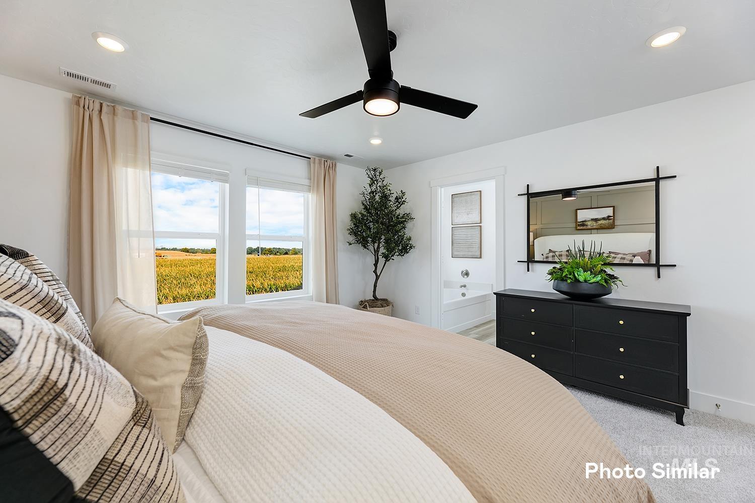 Bedroom with light carpet, a water view, recessed lighting, connected bathroom, and ceiling fan