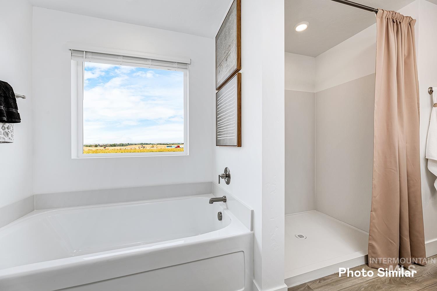 Bathroom featuring a garden tub and a shower stall