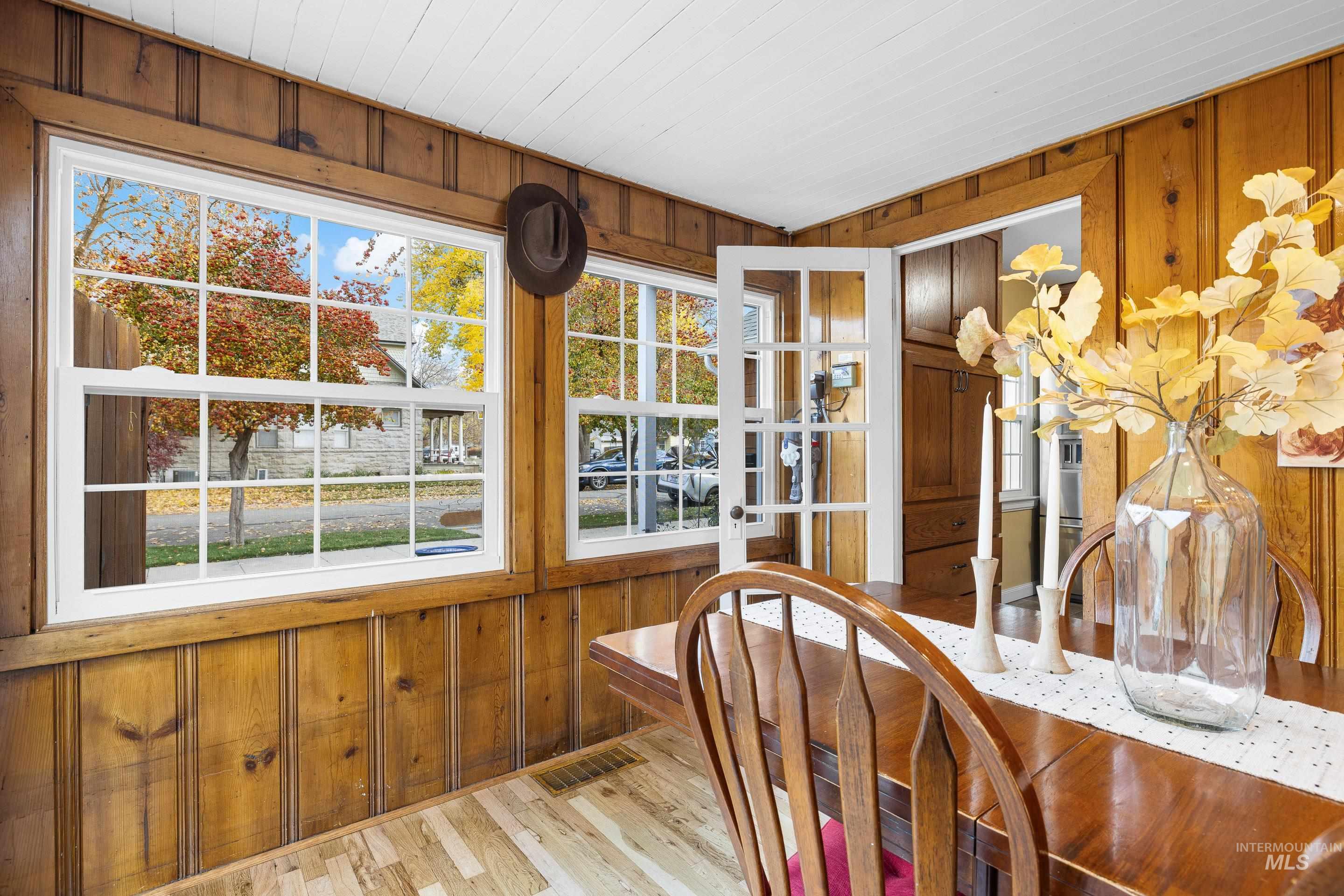 Dining area with wood walls and light wood-style flooring