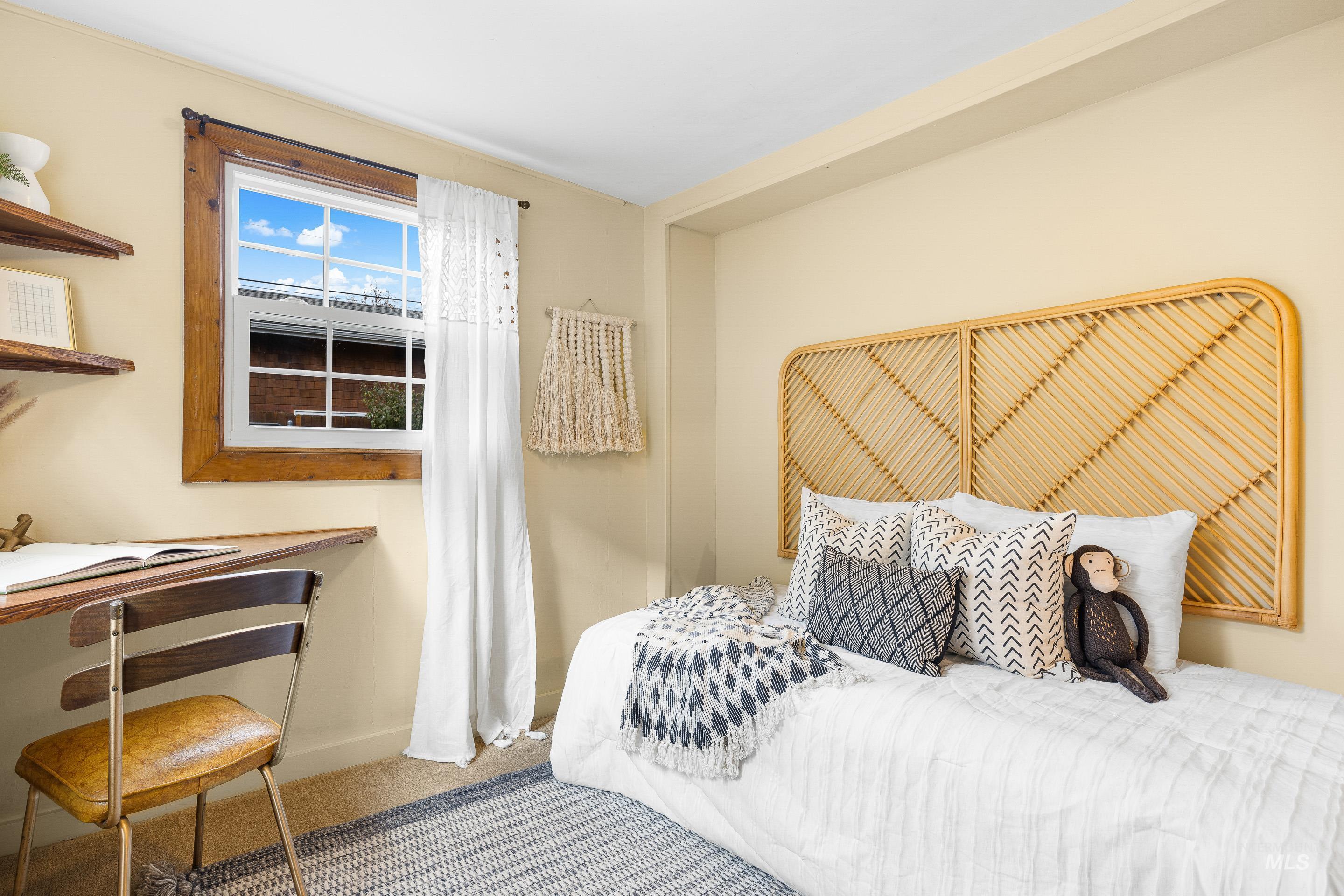 Carpeted bedroom featuring a desk and baseboards
