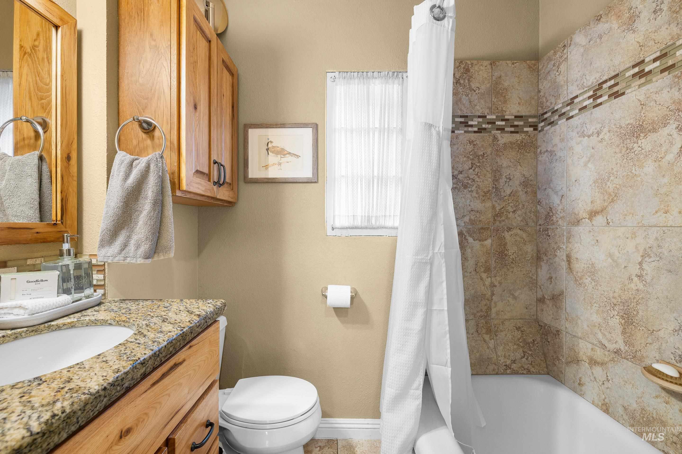 Full bathroom featuring shower / bathtub combination with curtain and vanity