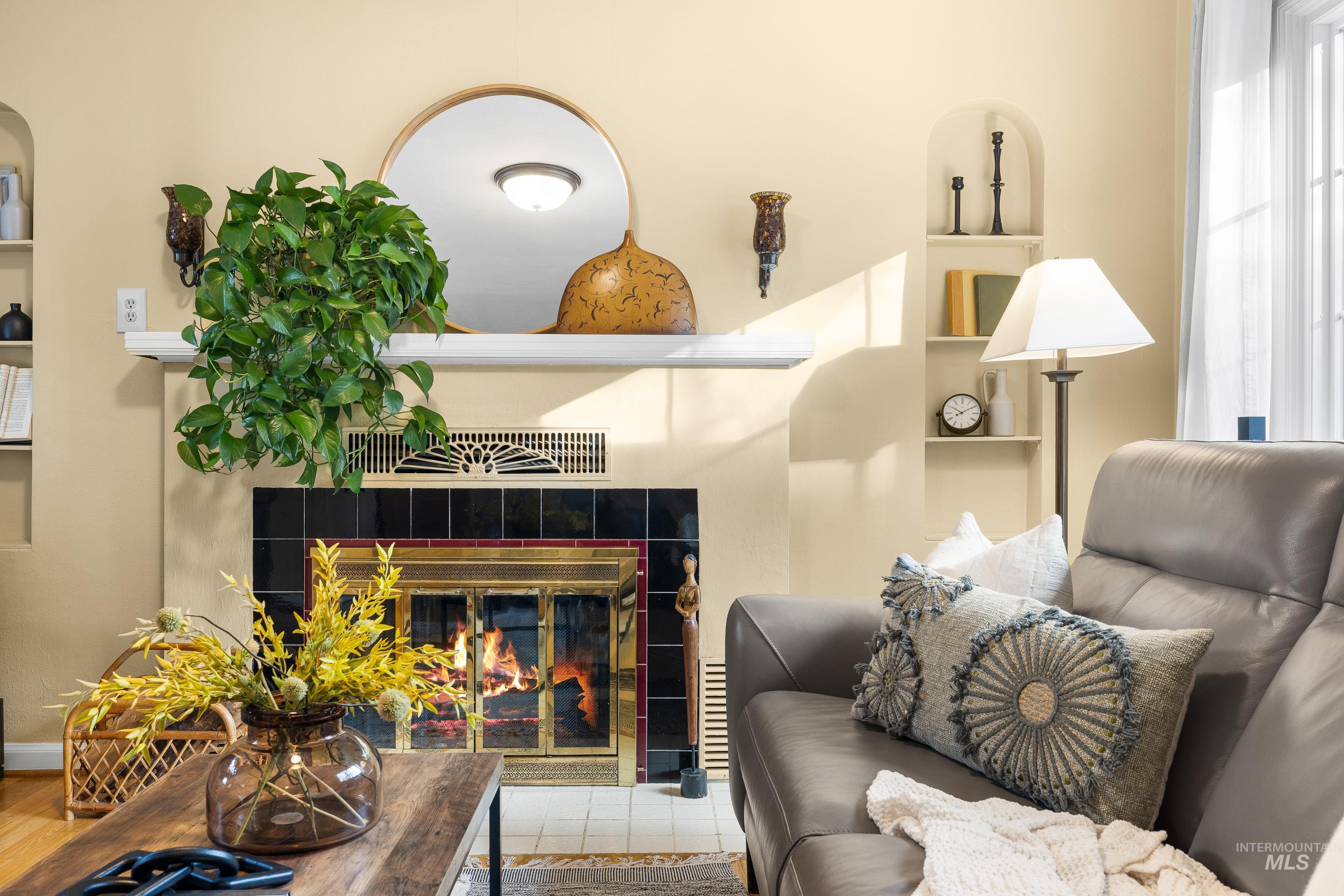 Living area featuring built in shelves, a tile fireplace, and plenty of natural light