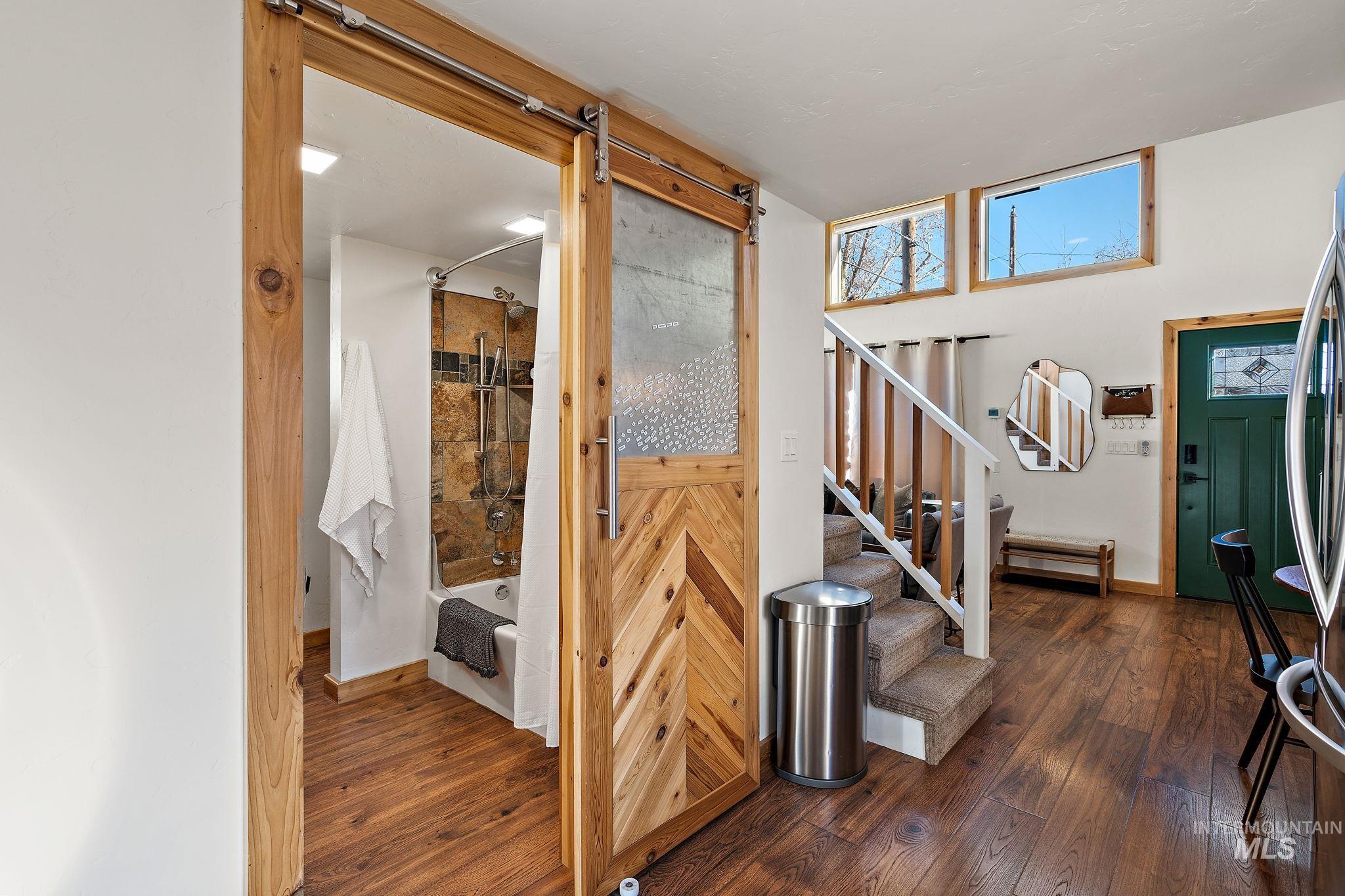 Stairs featuring a barn door and wood-type flooring
