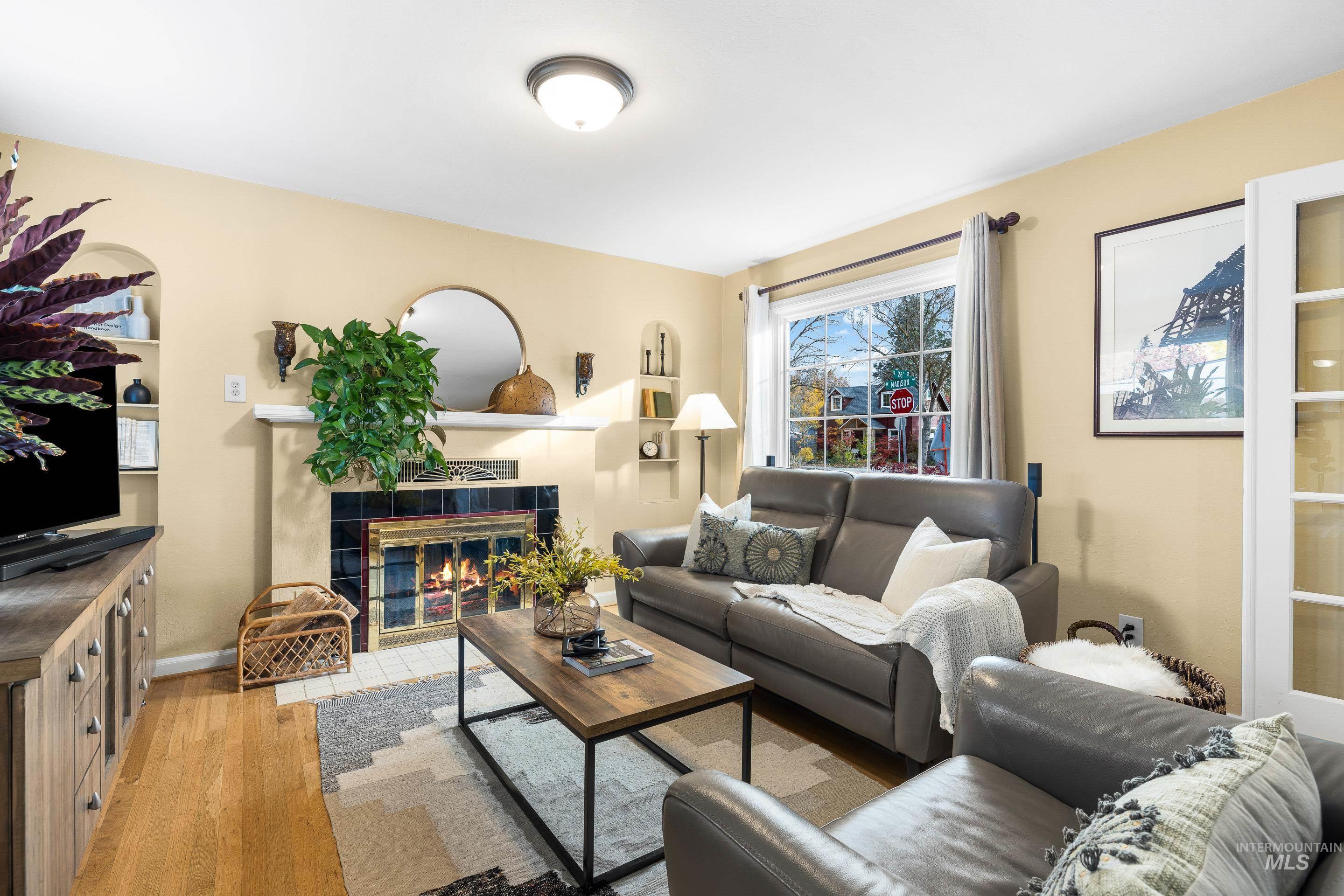 Living room featuring light wood-type flooring and a tile fireplace