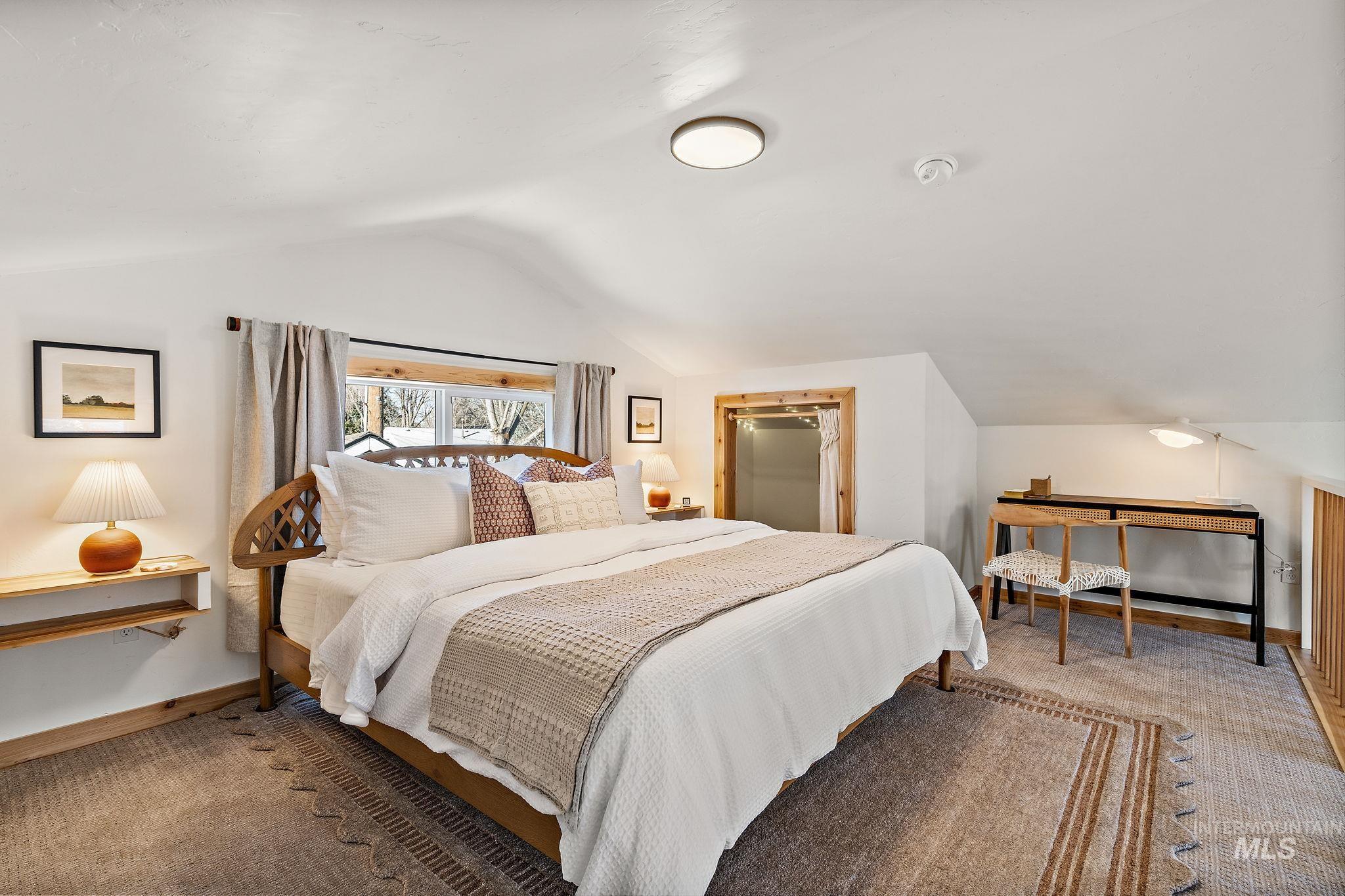 Bedroom featuring vaulted ceiling and baseboards
