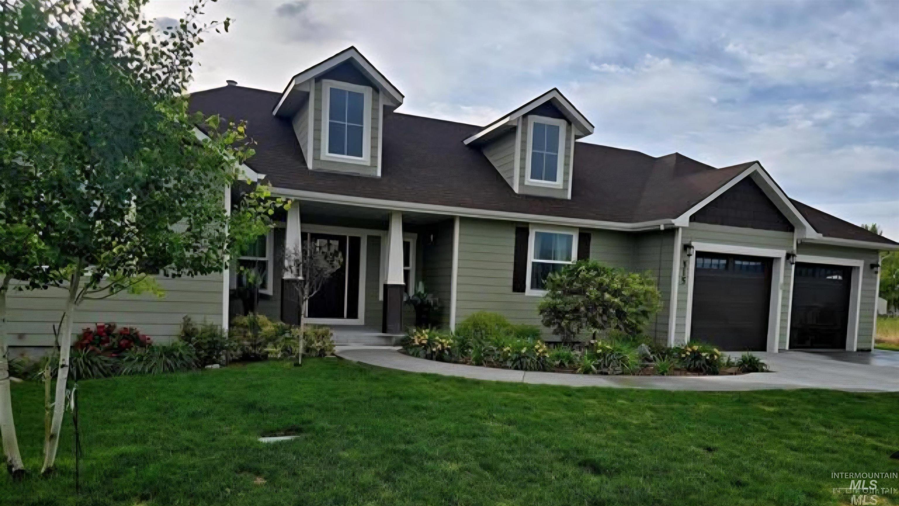 View of front facade with a front yard, an attached garage, and driveway