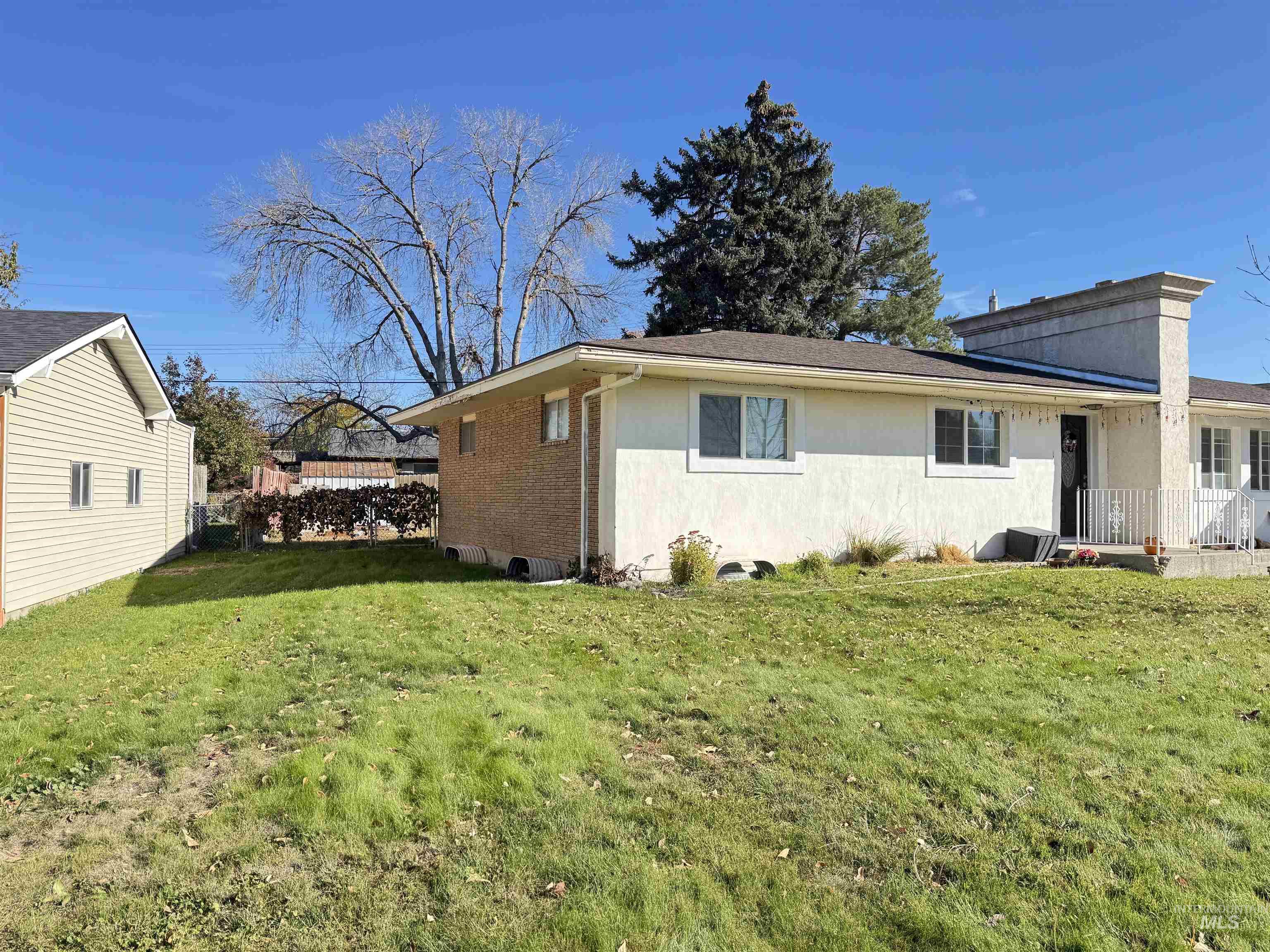 View of home's exterior with a yard, brick siding, and stucco siding