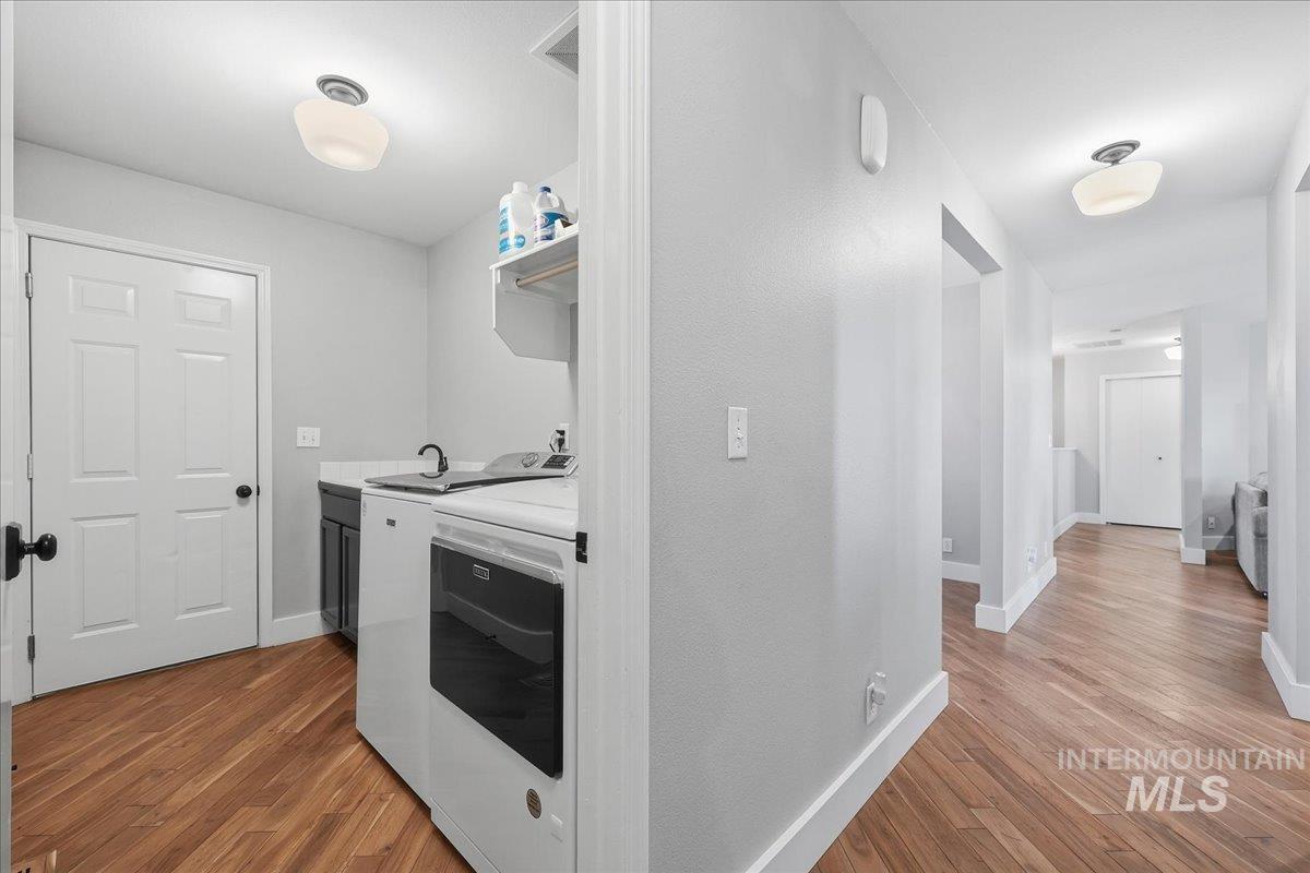 Laundry room featuring dark wood-style floors and baseboards