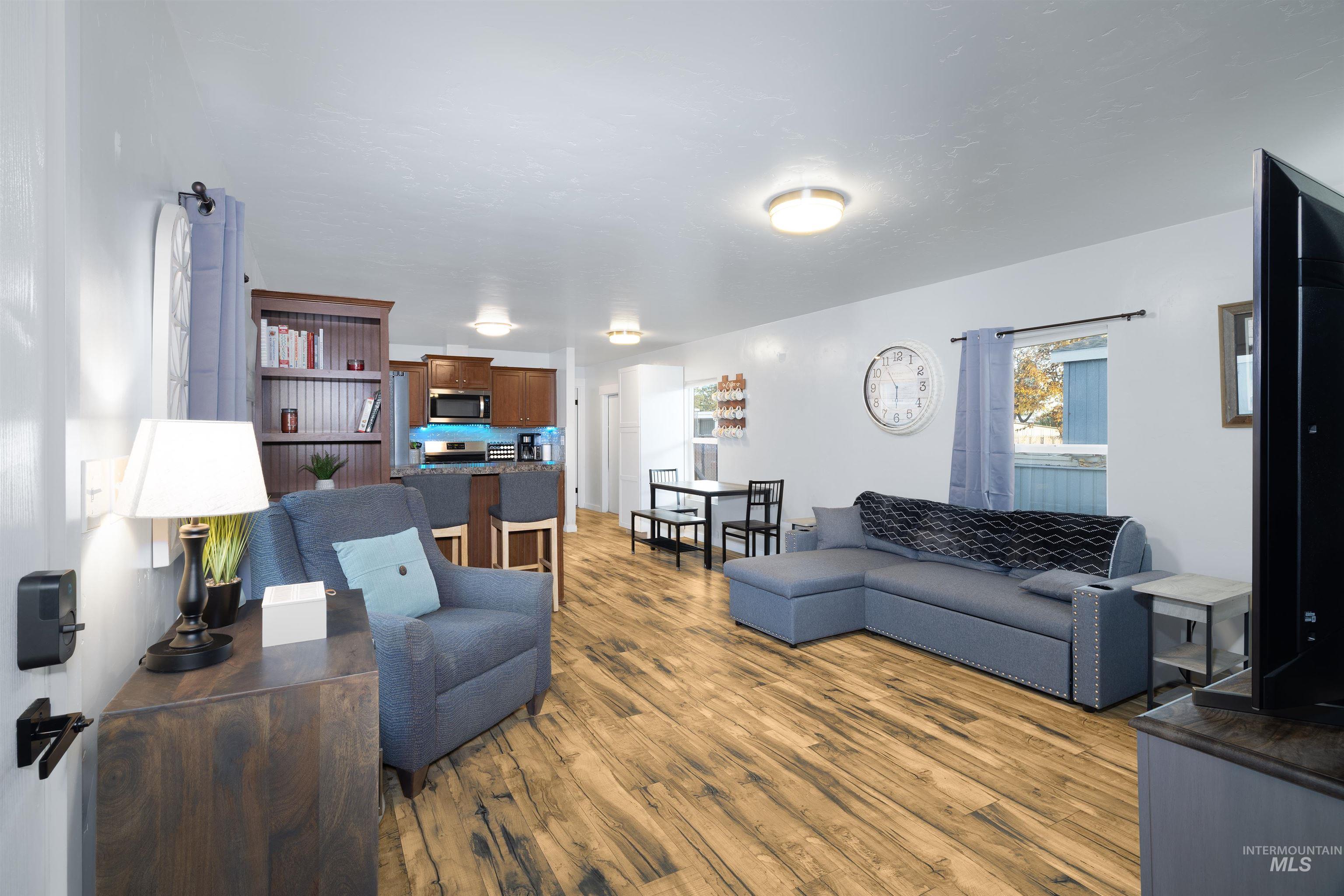 Roomy living room with plenty of natural light and vinyl plank floors throughout