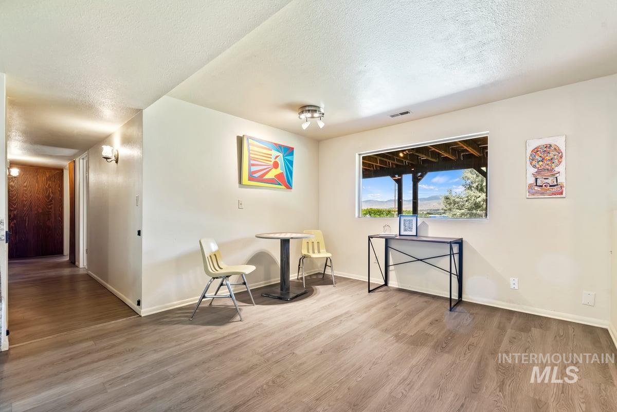 Sitting room with wood finished floors and a textured ceiling