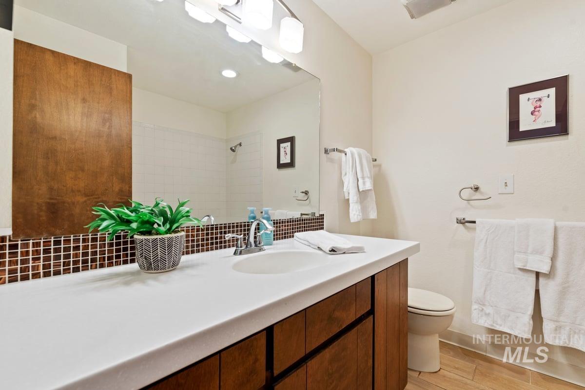 Full bathroom featuring vanity, wood finished floors, and a shower