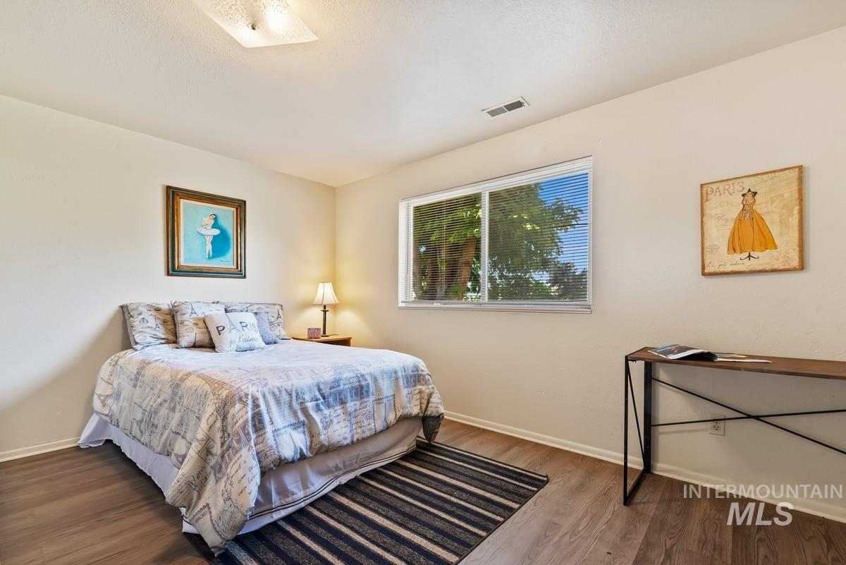 Bedroom featuring wood finished floors and baseboards