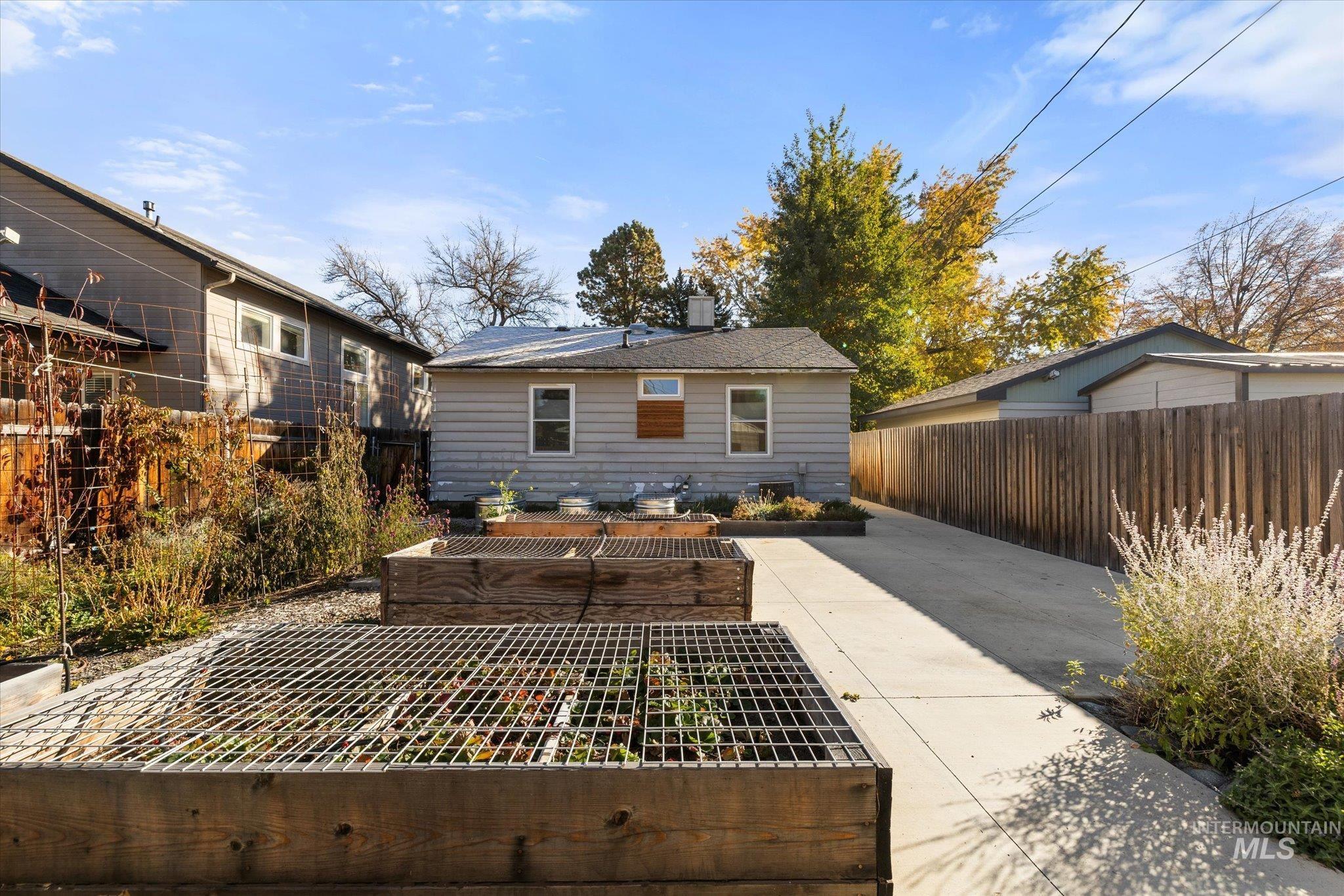 Back of property with a garden, a patio, a fenced backyard, and a chimney