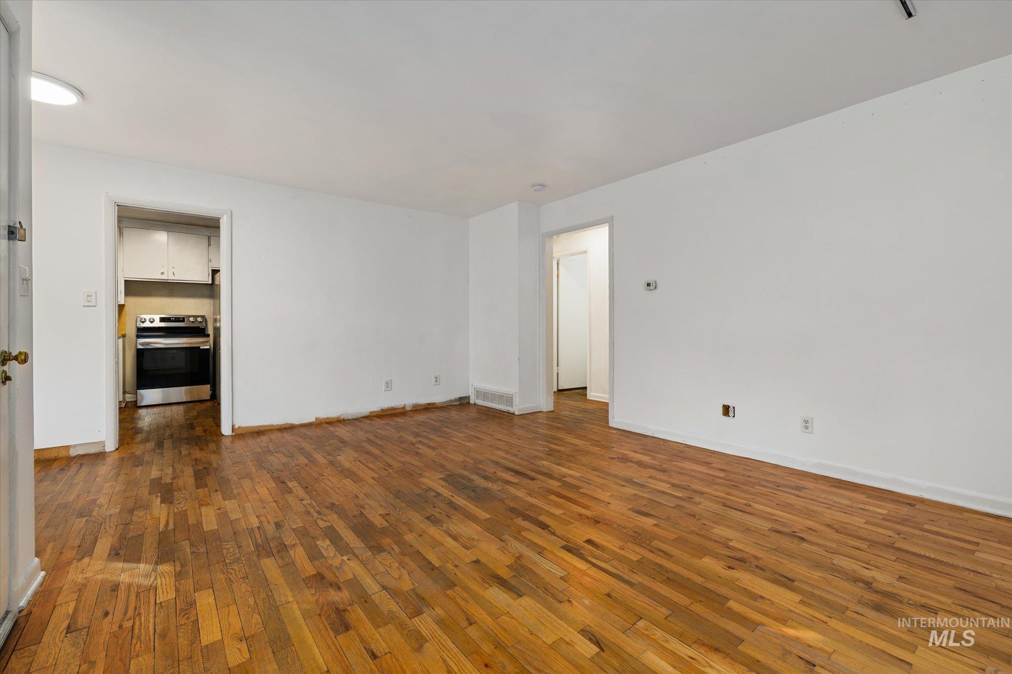 Empty room with dark wood-style floors and baseboards