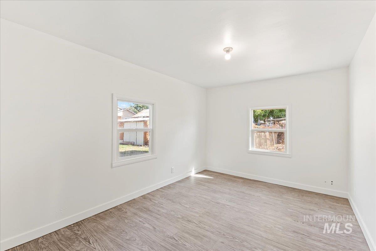 Empty room with light wood-style floors and baseboards