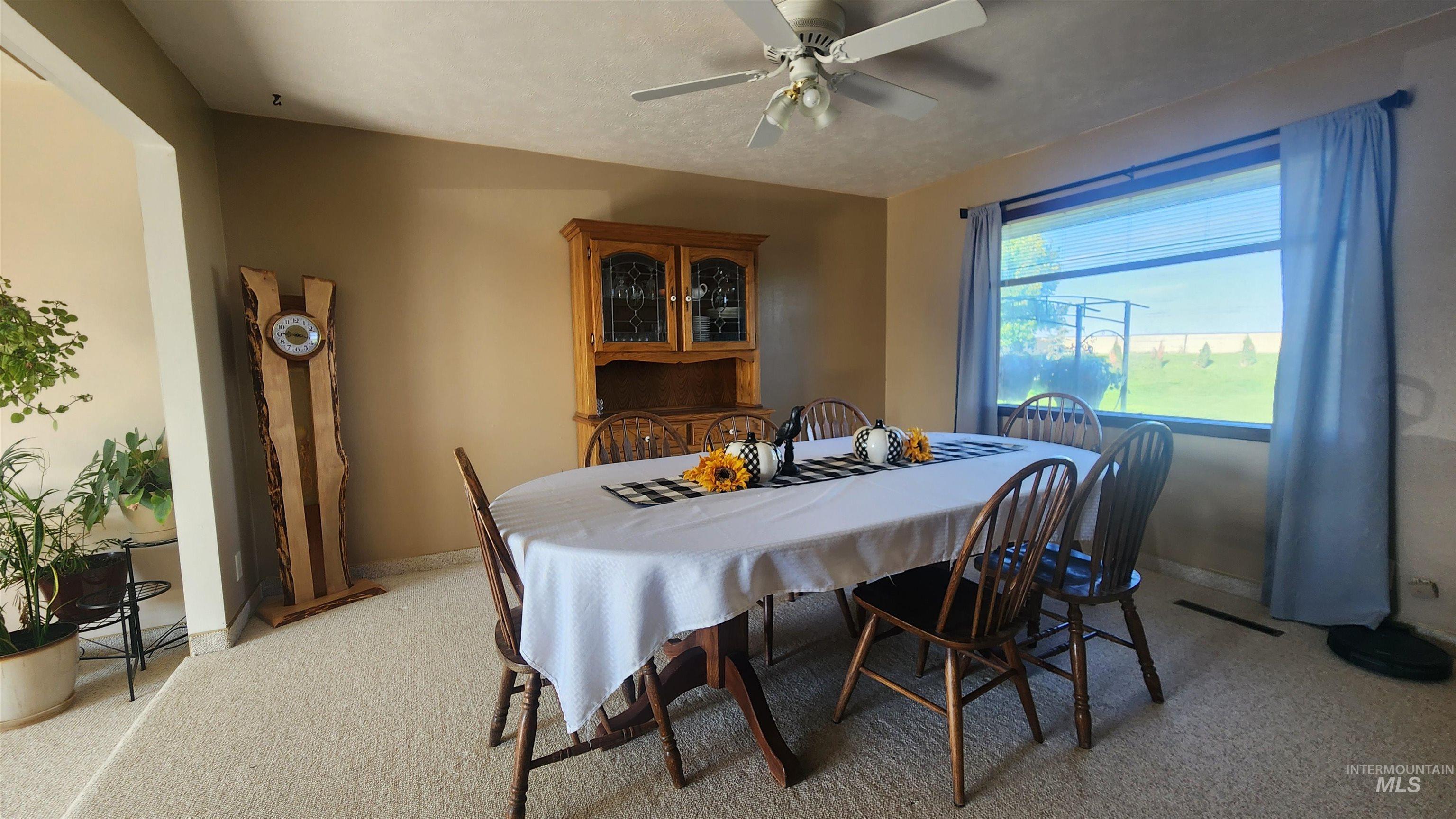 Dining room with light carpet and ceiling fan