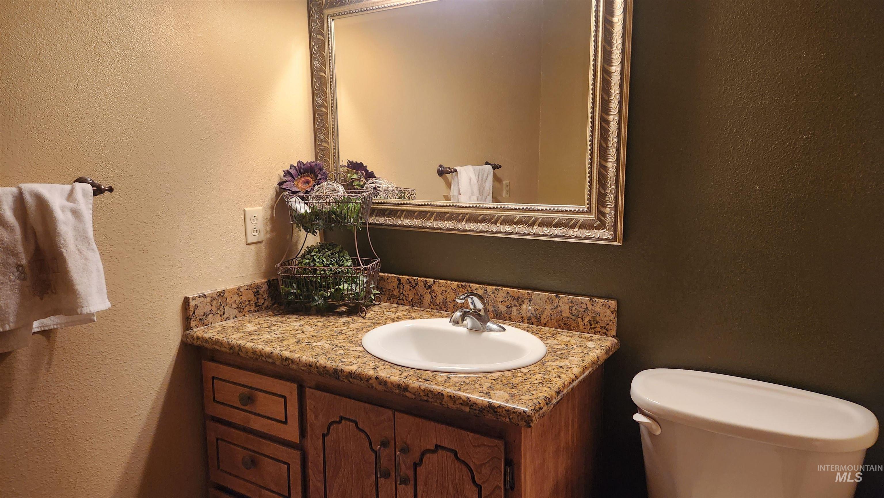 Bathroom featuring a textured wall and vanity