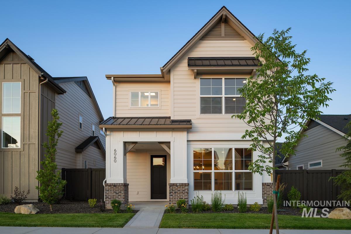 View of front facade featuring a metal roof, a standing seam roof, brick siding, and board and batten siding