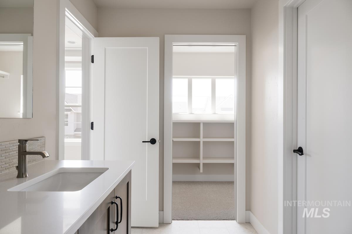 Bathroom with vanity, plenty of natural light, and light carpet