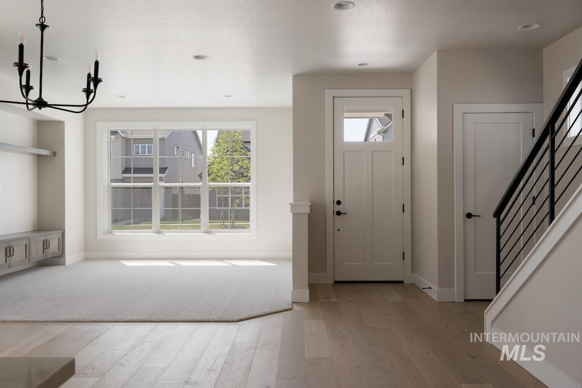 Foyer entrance with light wood-style floors, stairway, recessed lighting, and a chandelier