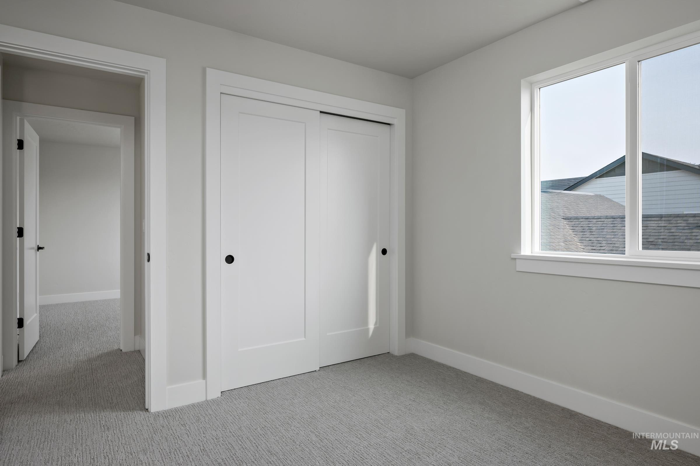Unfurnished bedroom with light carpet and a closet