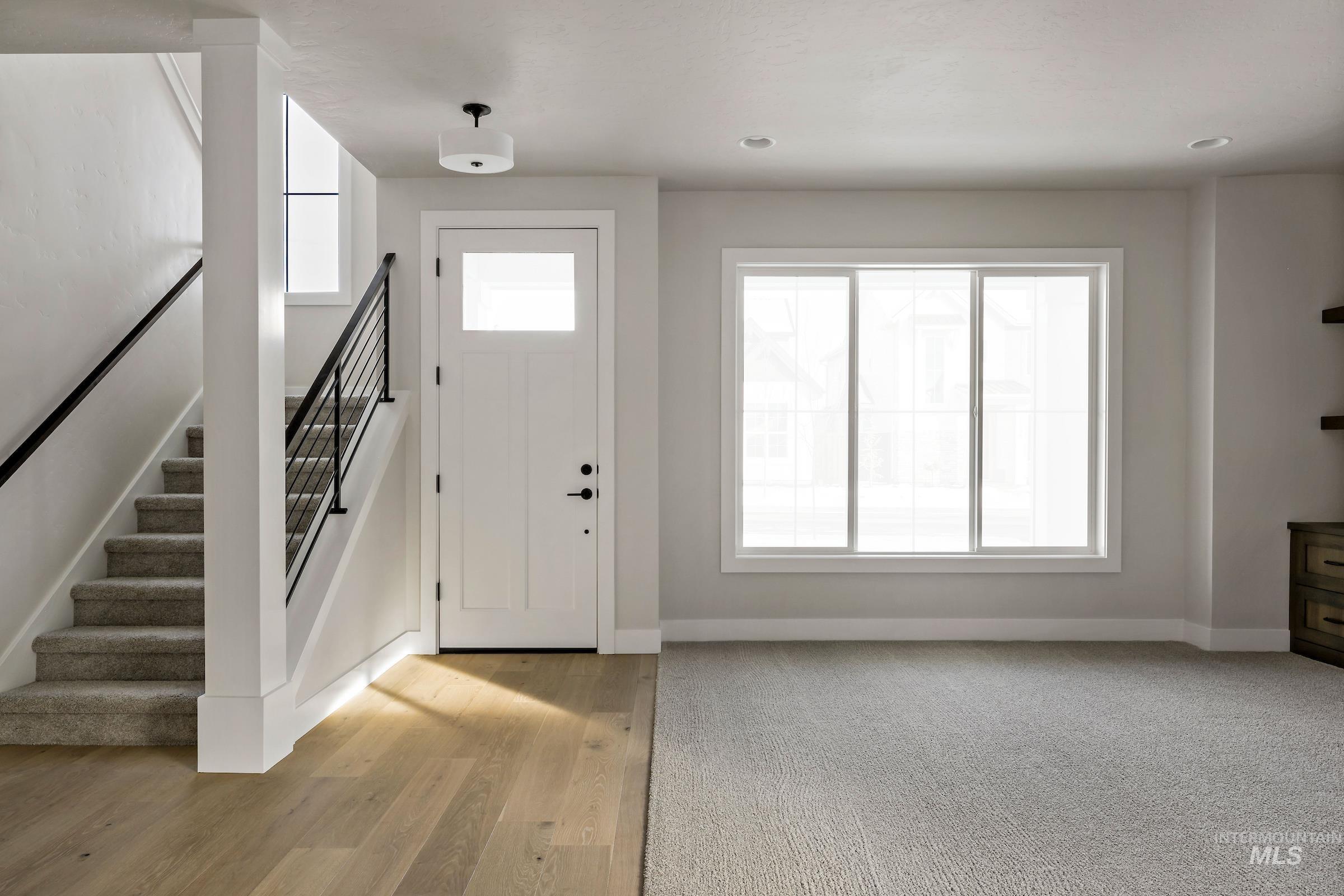 Foyer entrance with stairs and light wood finished floors