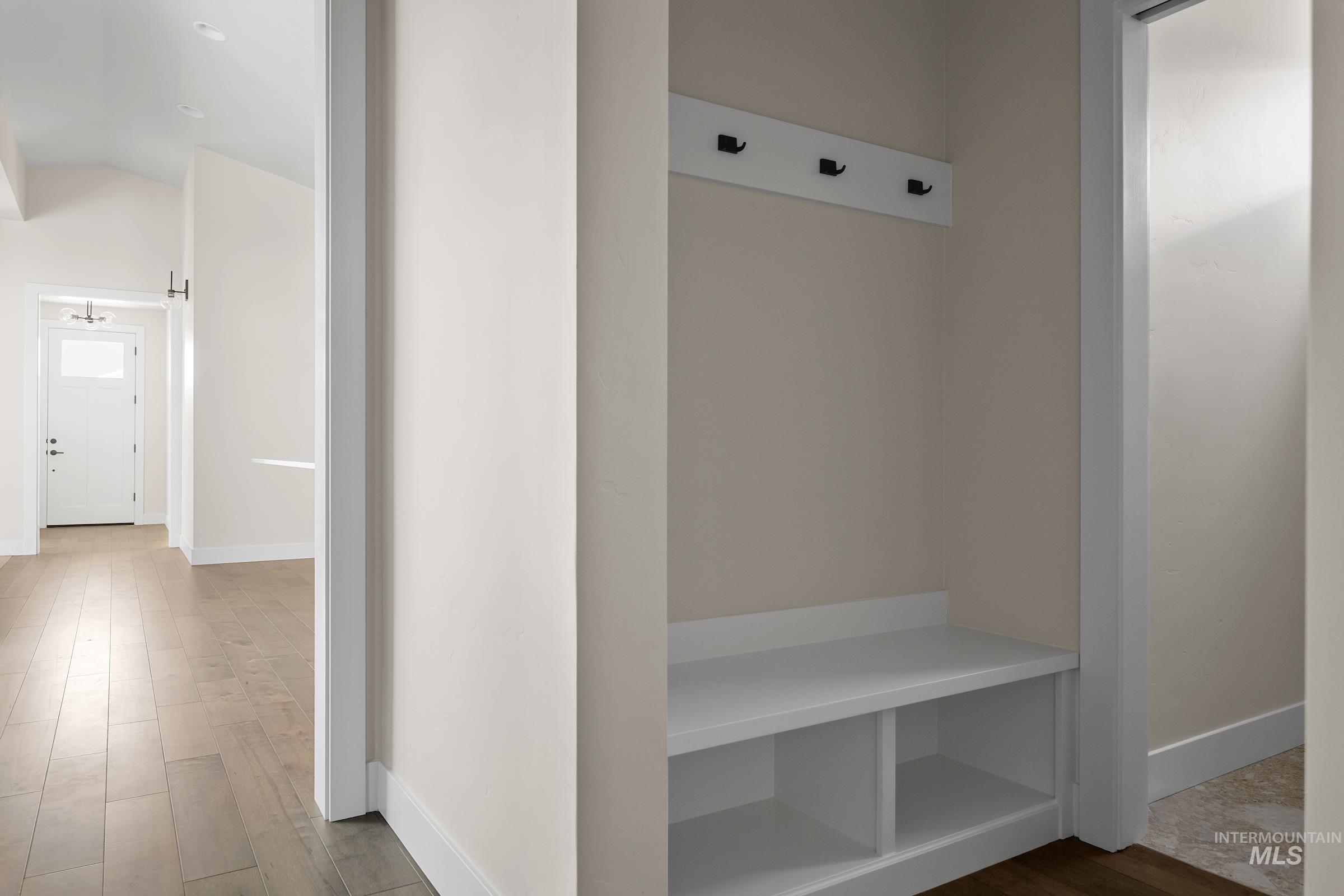 Mudroom featuring wood finished floors and lofted ceiling