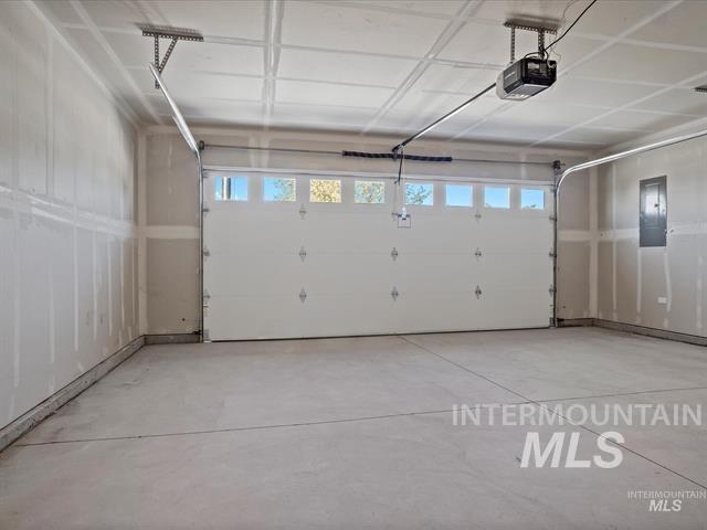 Garage featuring a garage door opener and electric panel