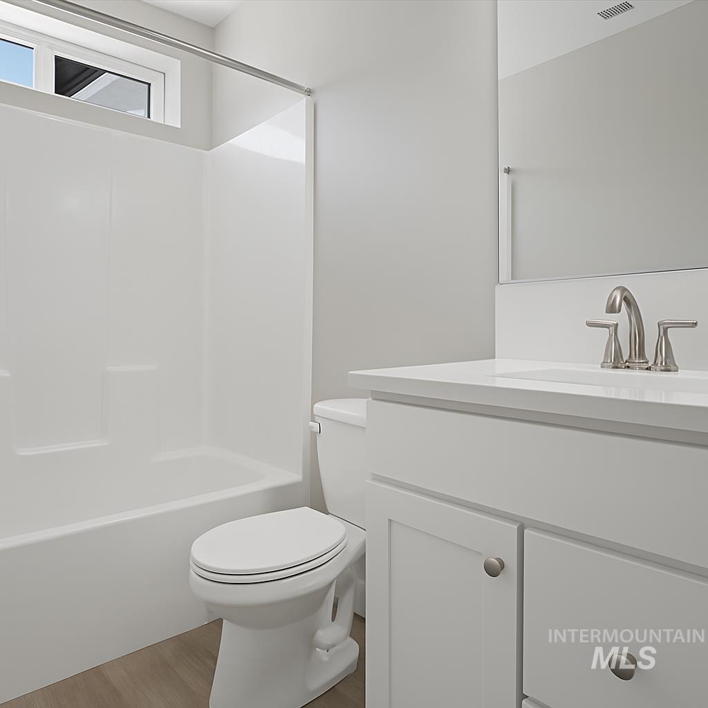Full bath featuring vanity, bathing tub / shower combination, and light wood-type flooring
