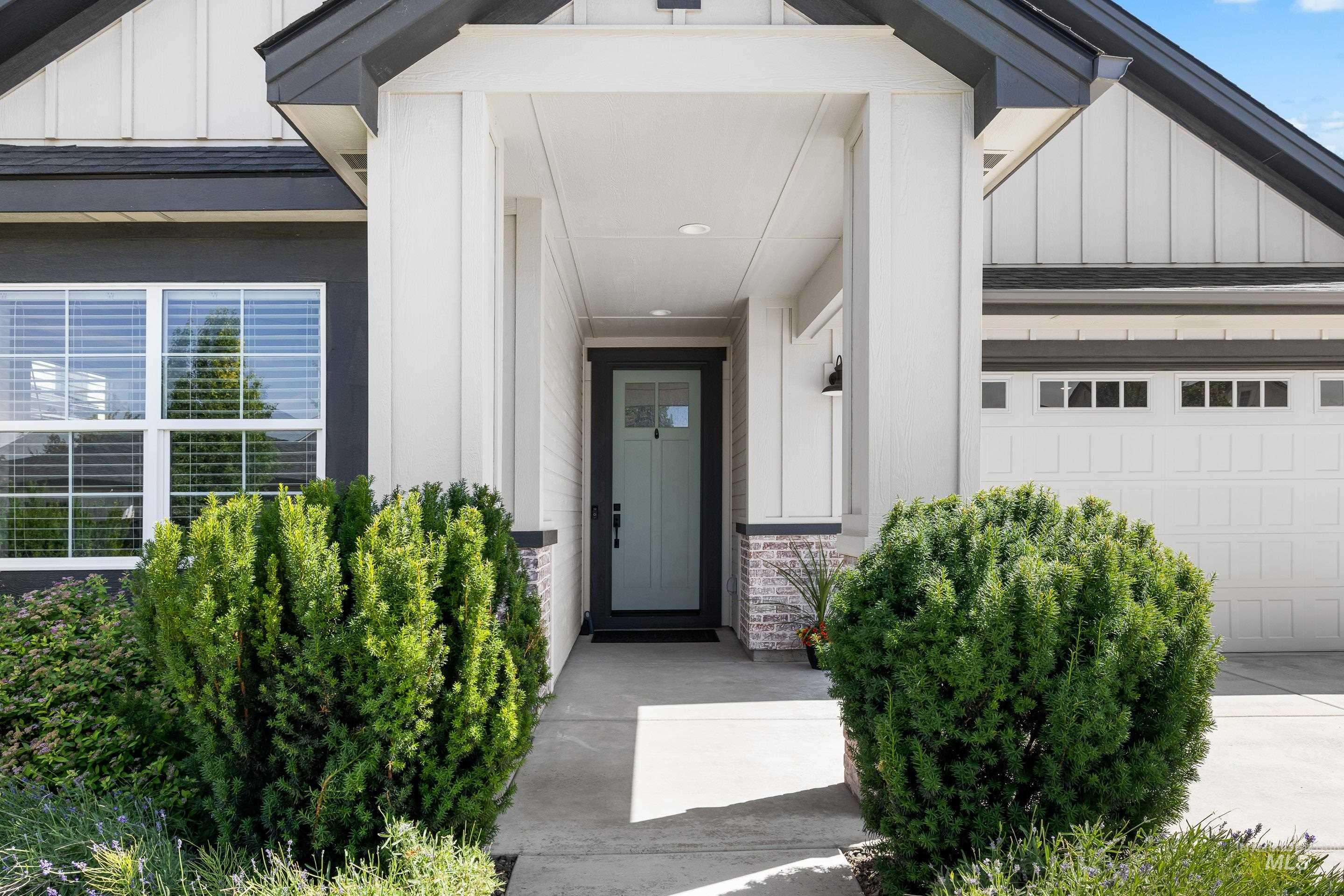View of exterior entry featuring board and batten siding and an attached garage