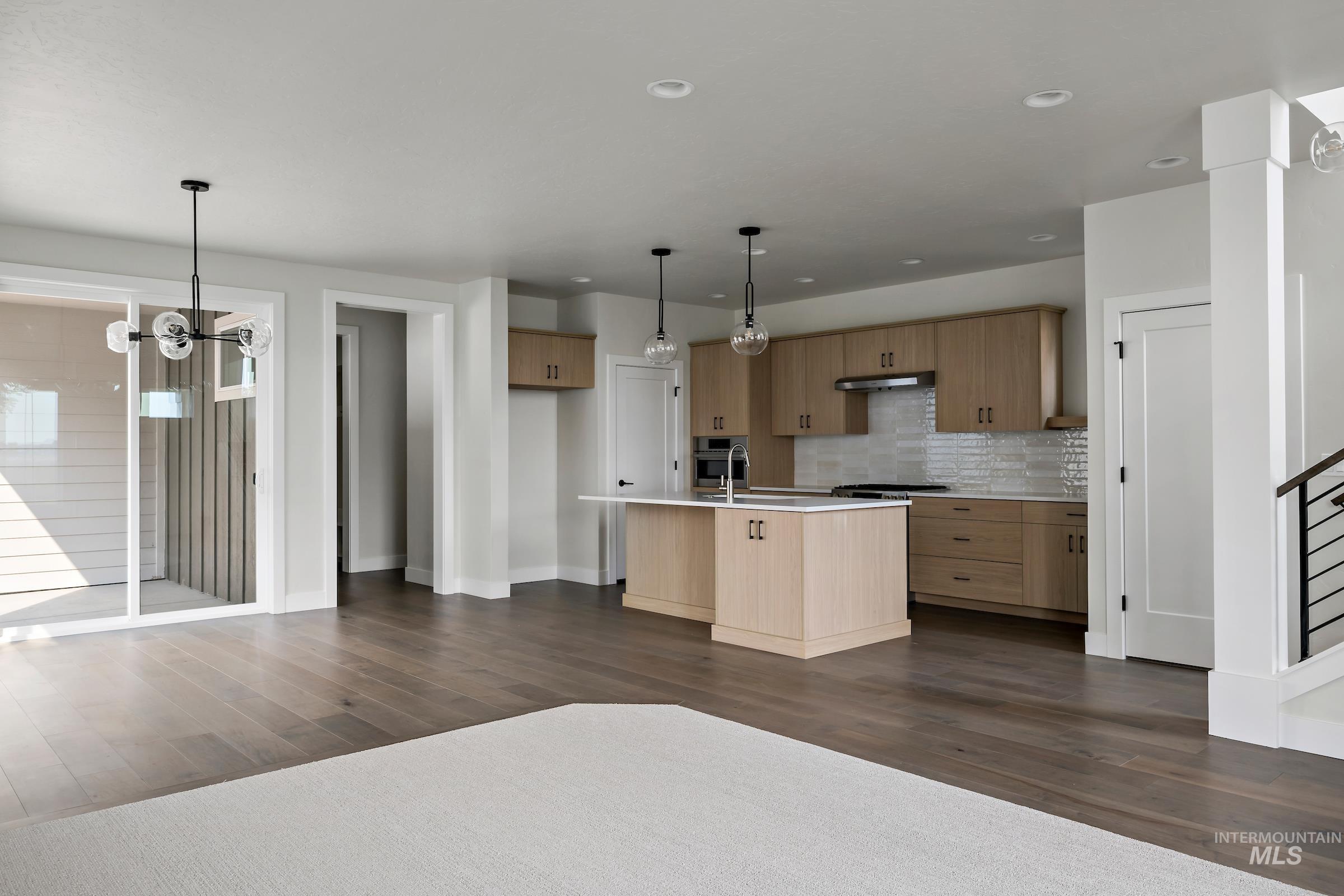 Kitchen featuring pendant lighting, dark wood-style flooring, a chandelier, tasteful backsplash, and recessed lighting