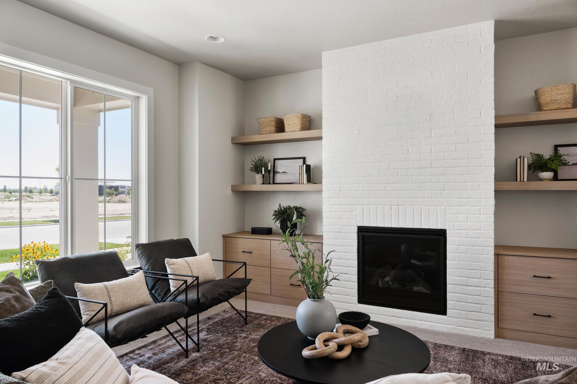 Living area featuring a brick fireplace and built in shelves
