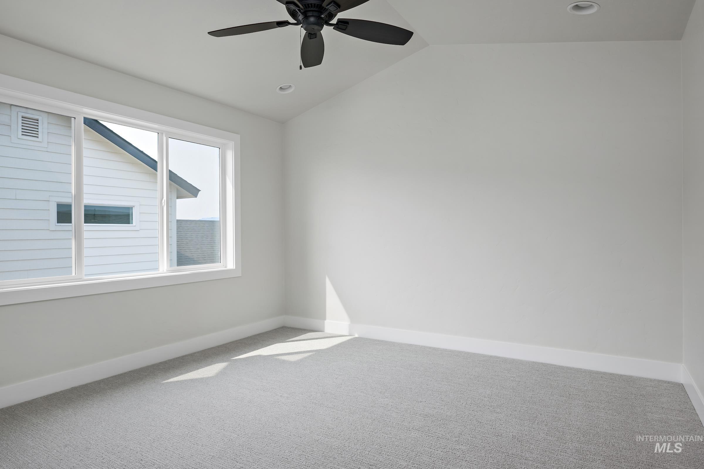 Carpeted spare room featuring lofted ceiling, ceiling fan, and recessed lighting