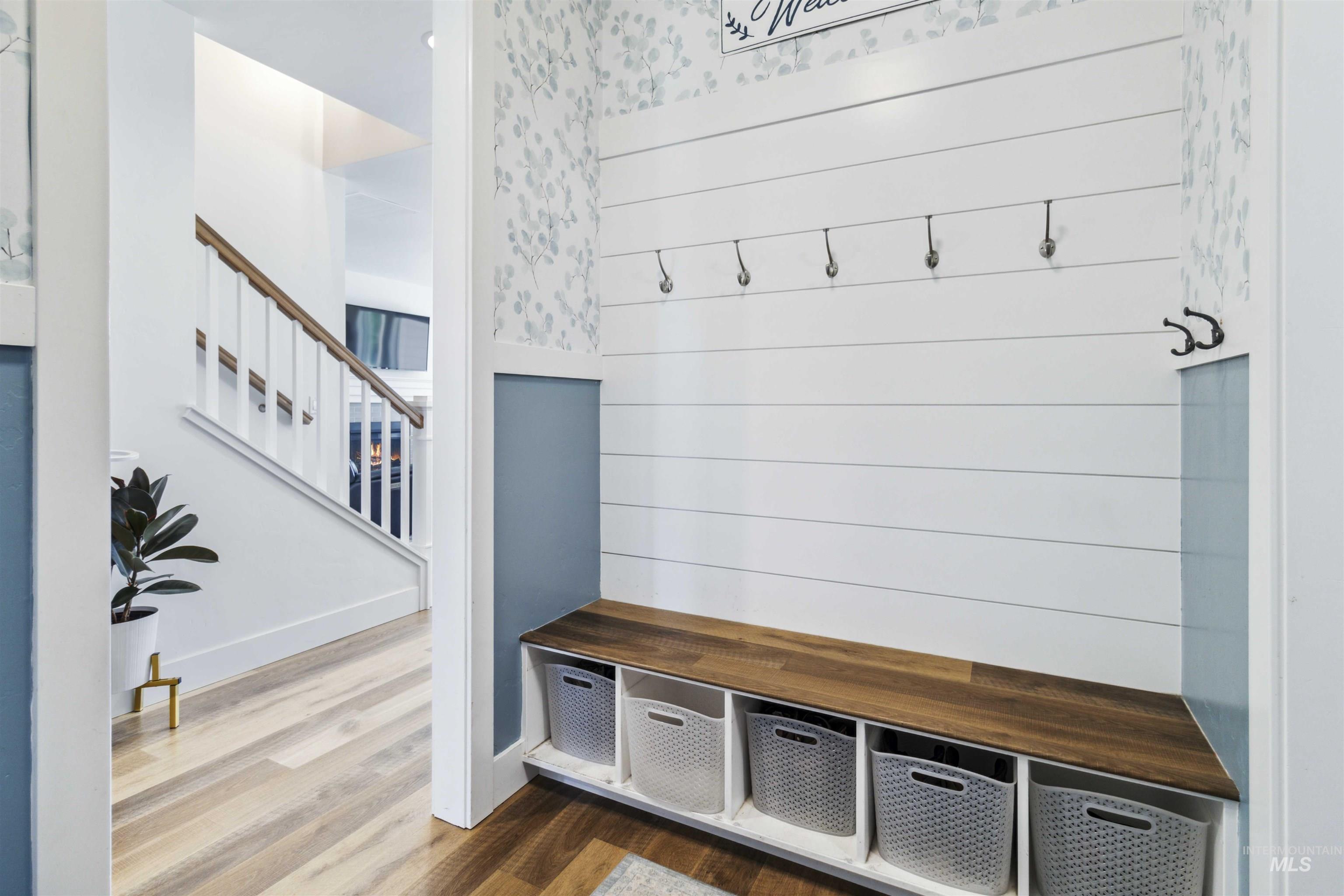 Mudroom featuring wood finished floors and wallpapered walls