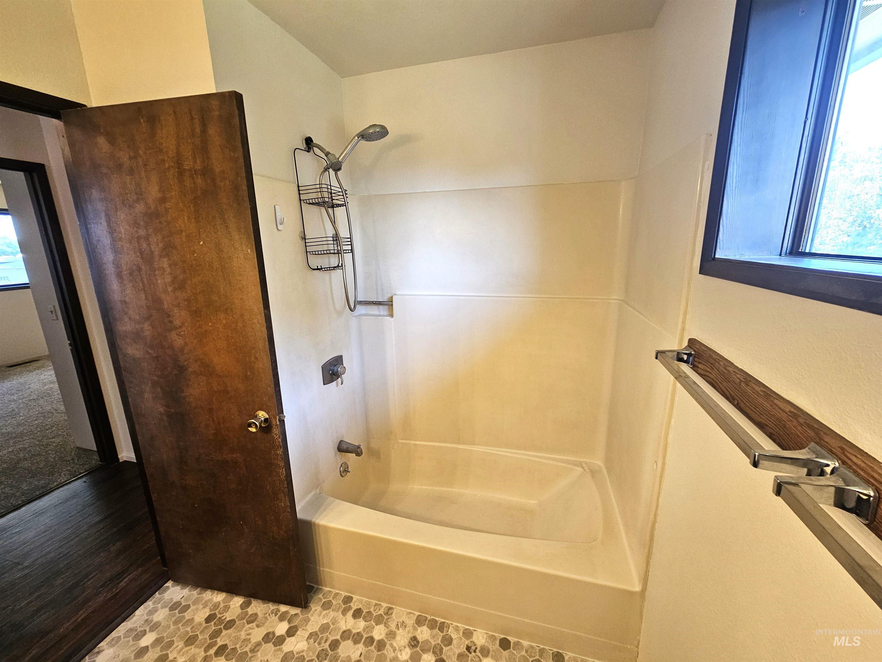 Bathroom featuring washtub / shower combination and tile patterned floors