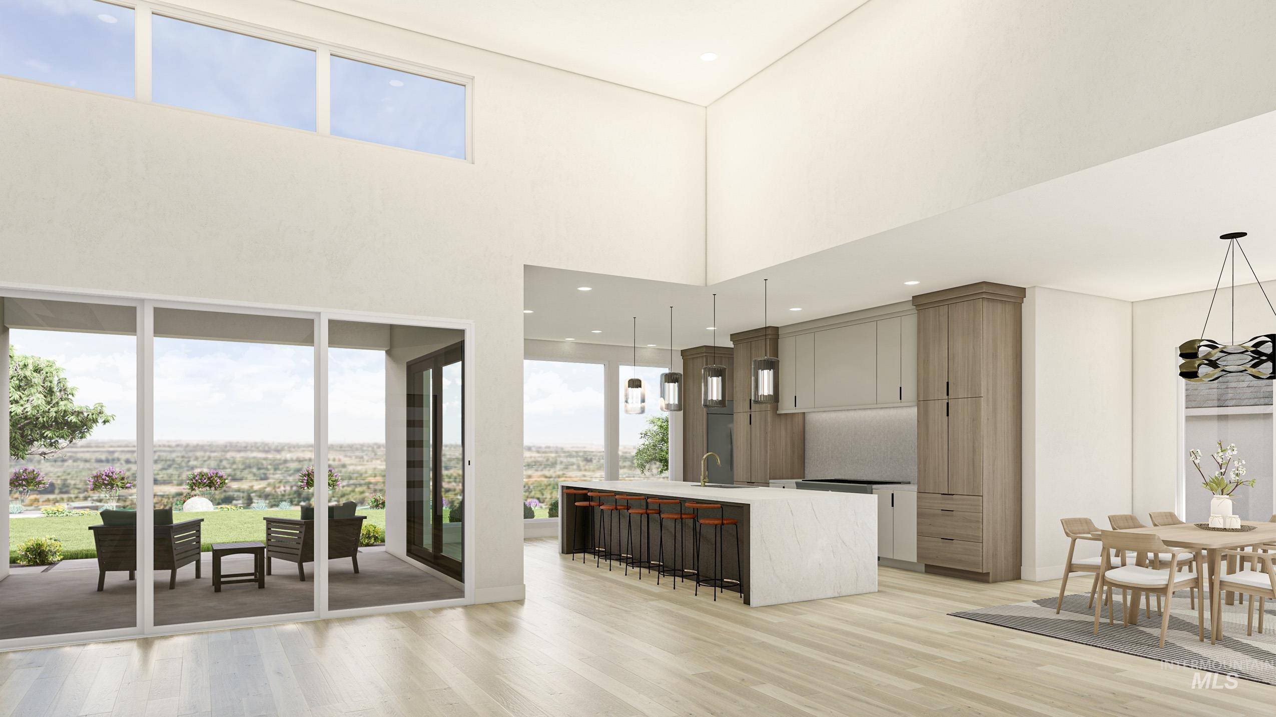 Kitchen with a kitchen island with sink, a kitchen breakfast bar, light wood finished floors, a high ceiling, and hanging light fixtures
