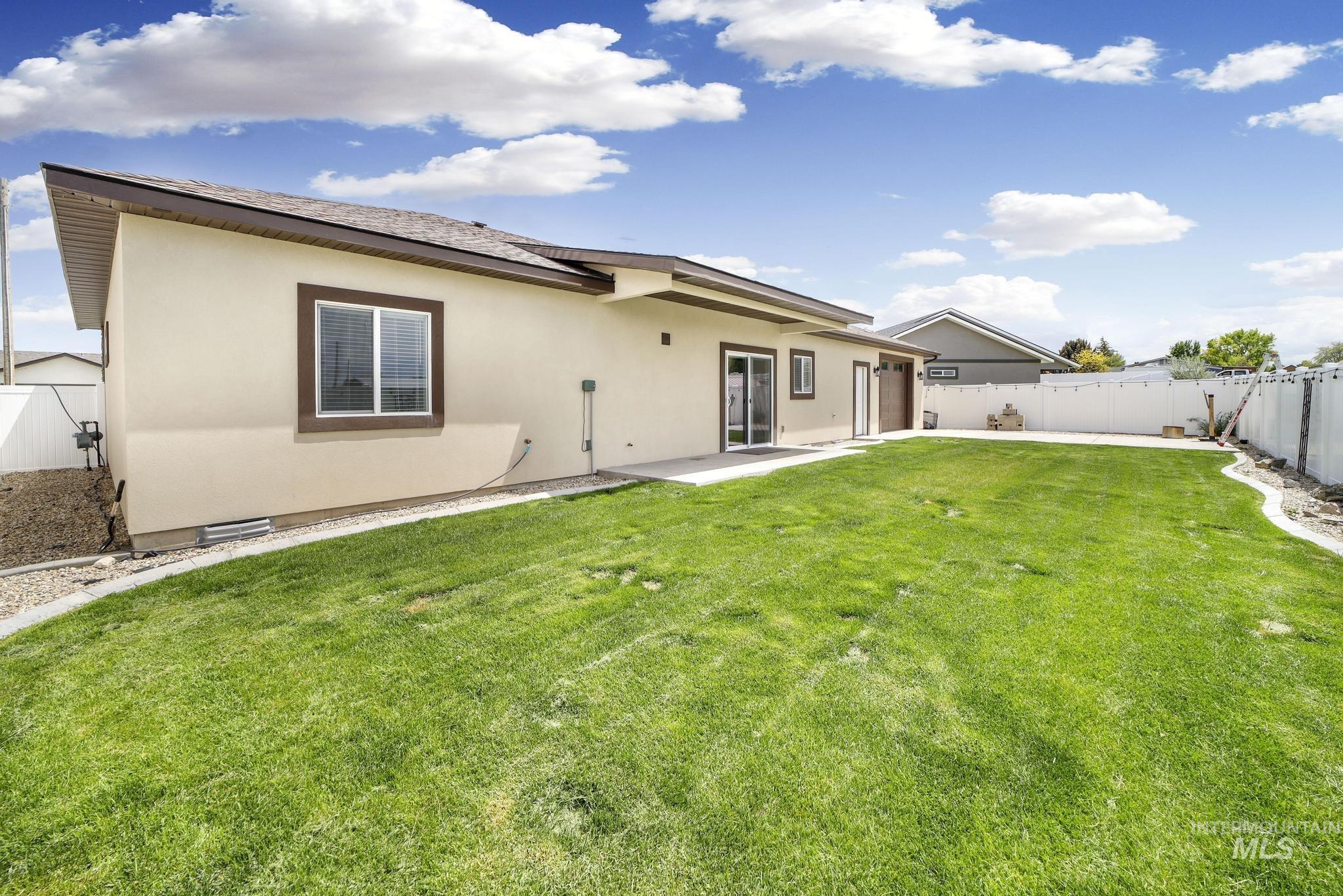 Rear view of house featuring a fenced backyard, stucco siding, and a patio
