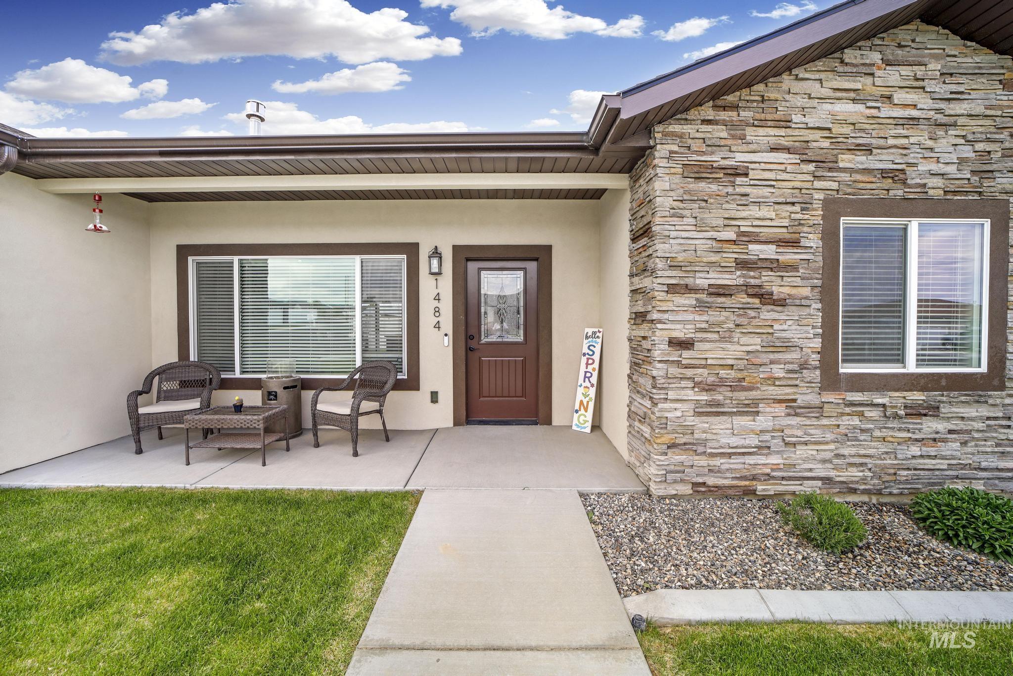 Property entrance with stucco siding, stone siding, covered porch, and an outdoor living space