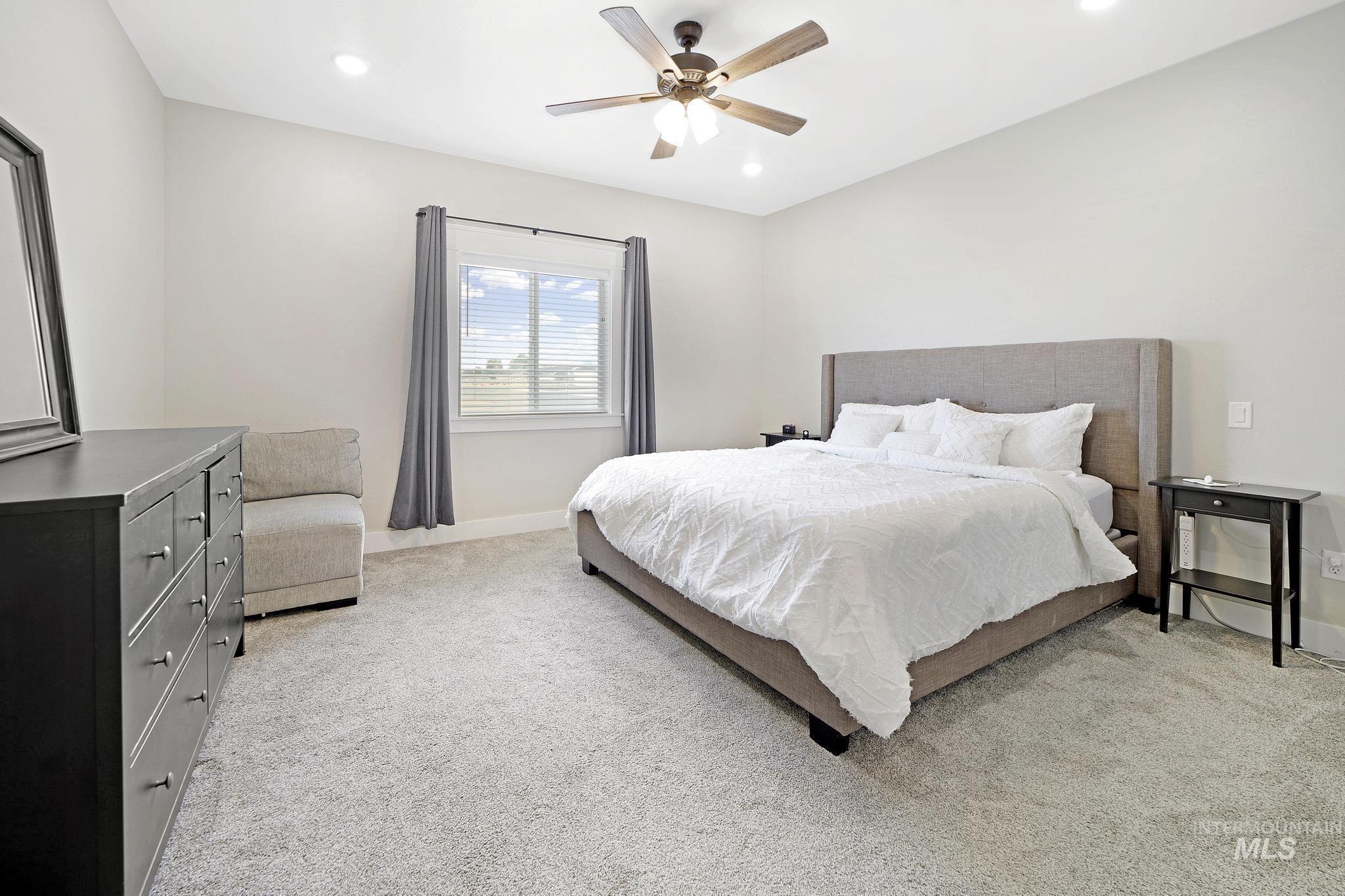 Bedroom with light colored carpet, a ceiling fan, and recessed lighting