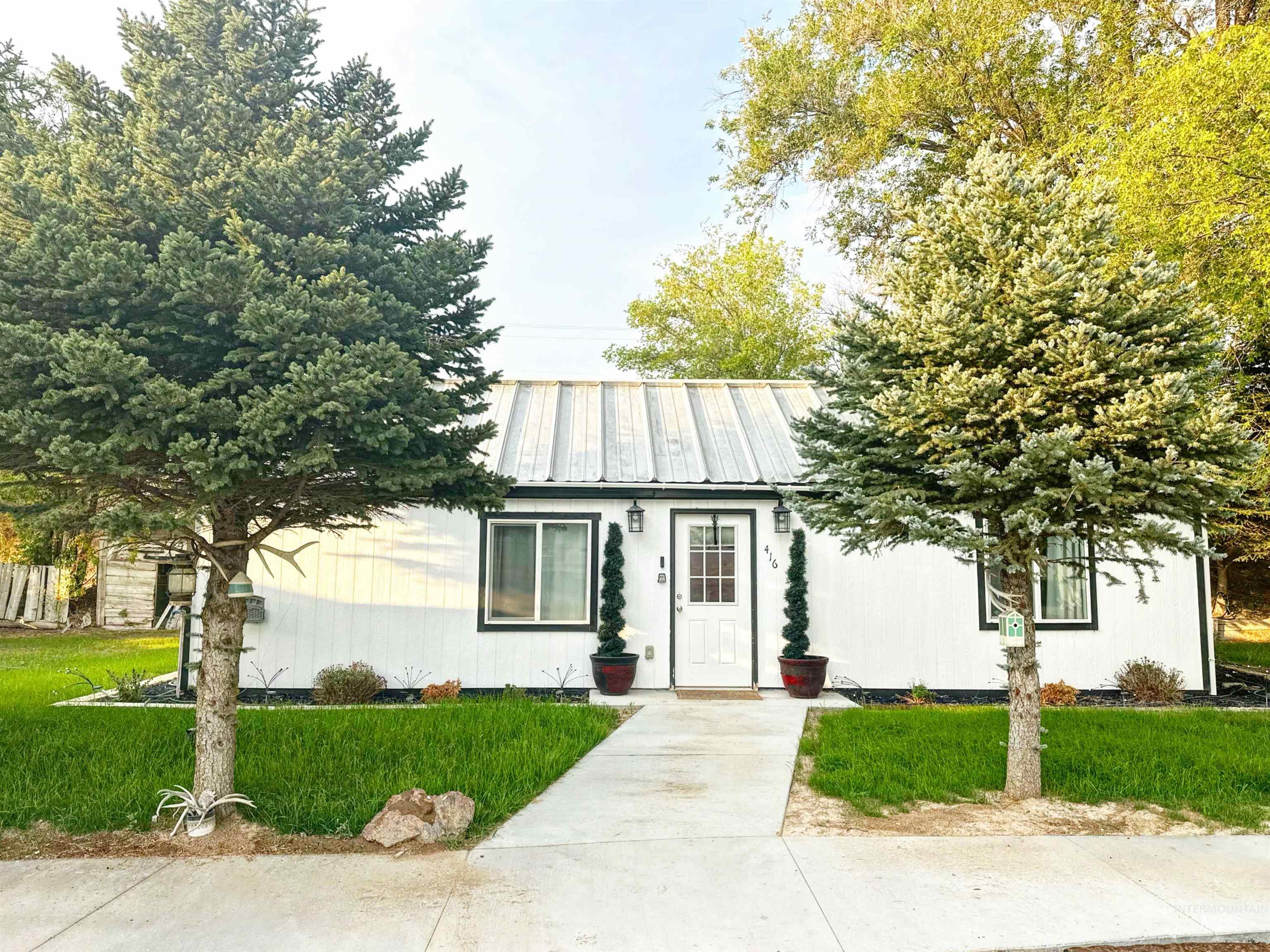 View of front of house with a front yard and a metal roof