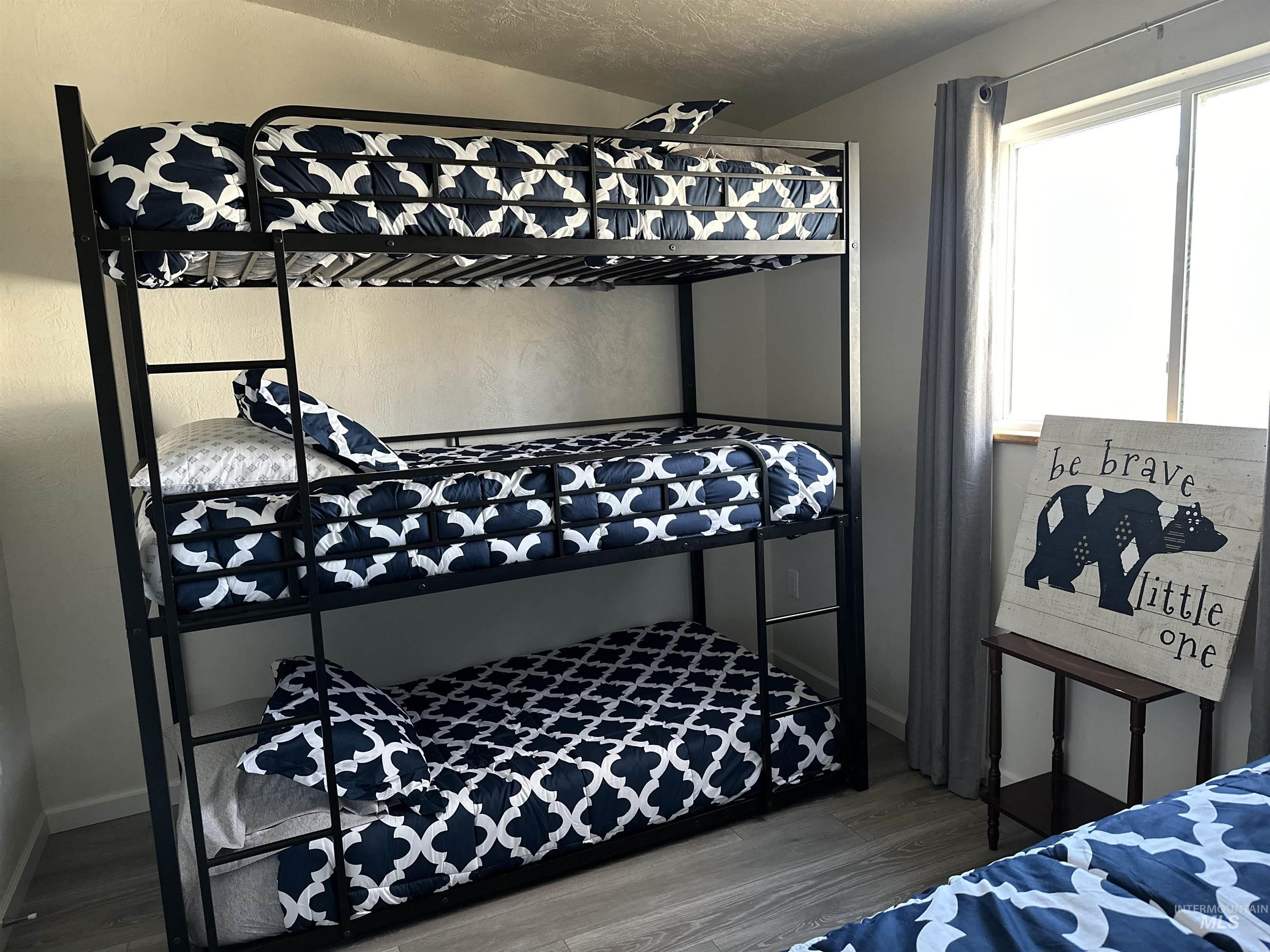 Bedroom featuring wood finished floors and a textured ceiling