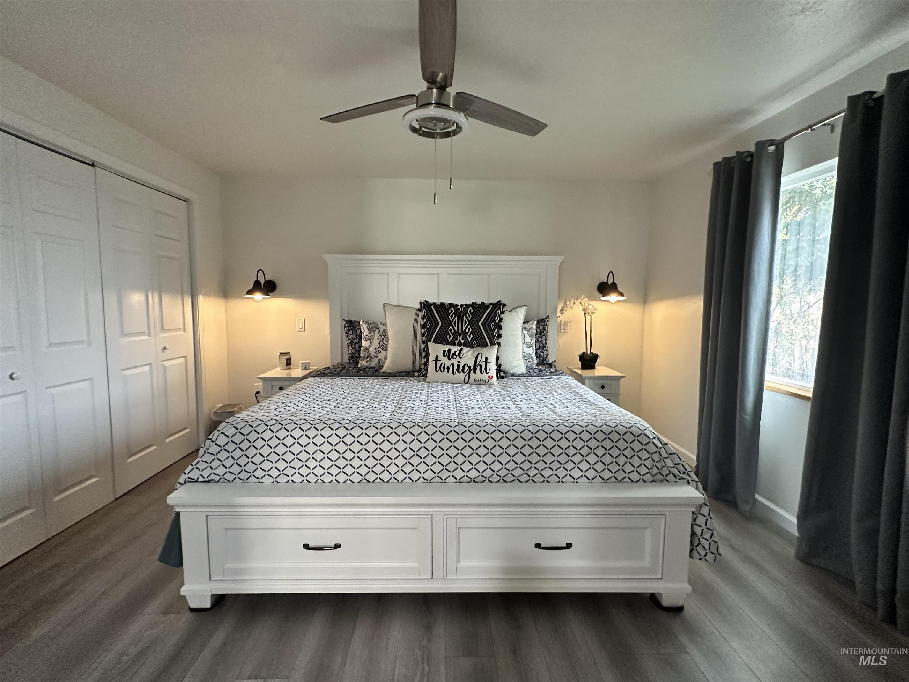 Bedroom featuring dark wood-style floors, a closet, and a ceiling fan