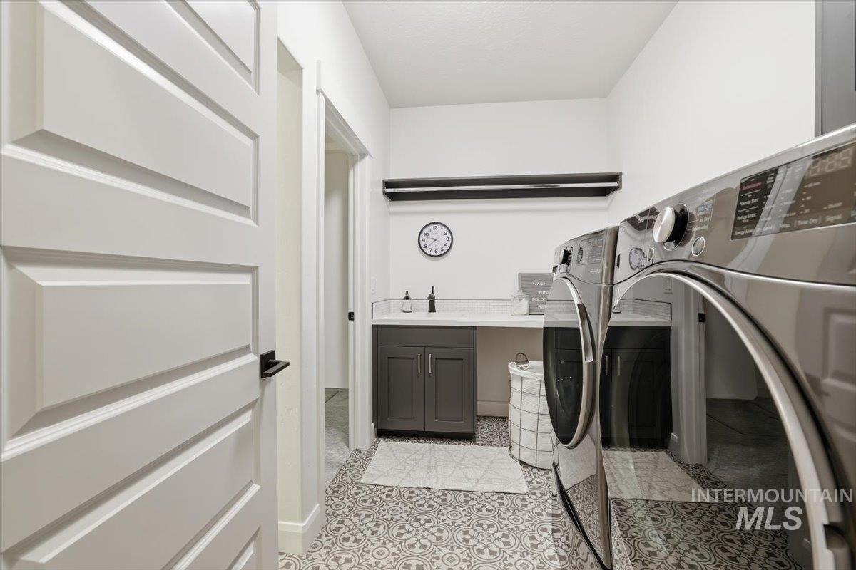 Laundry area featuring washing machine and clothes dryer, cabinet space, and light tile patterned floors
