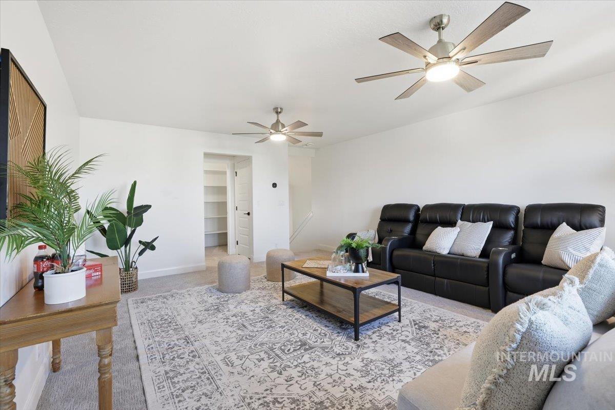 Living room with carpet floors and ceiling fan