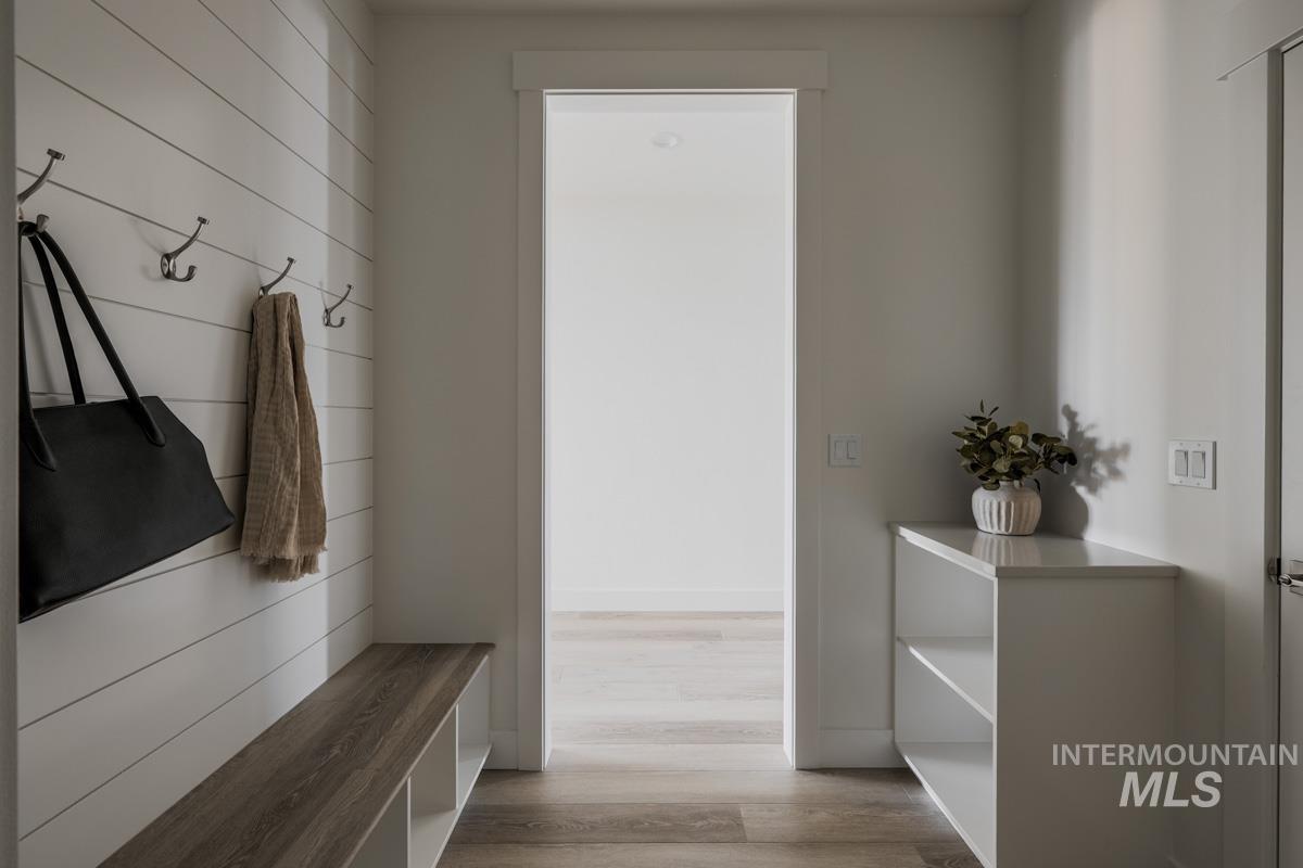 Mudroom with light wood-style floors and baseboards