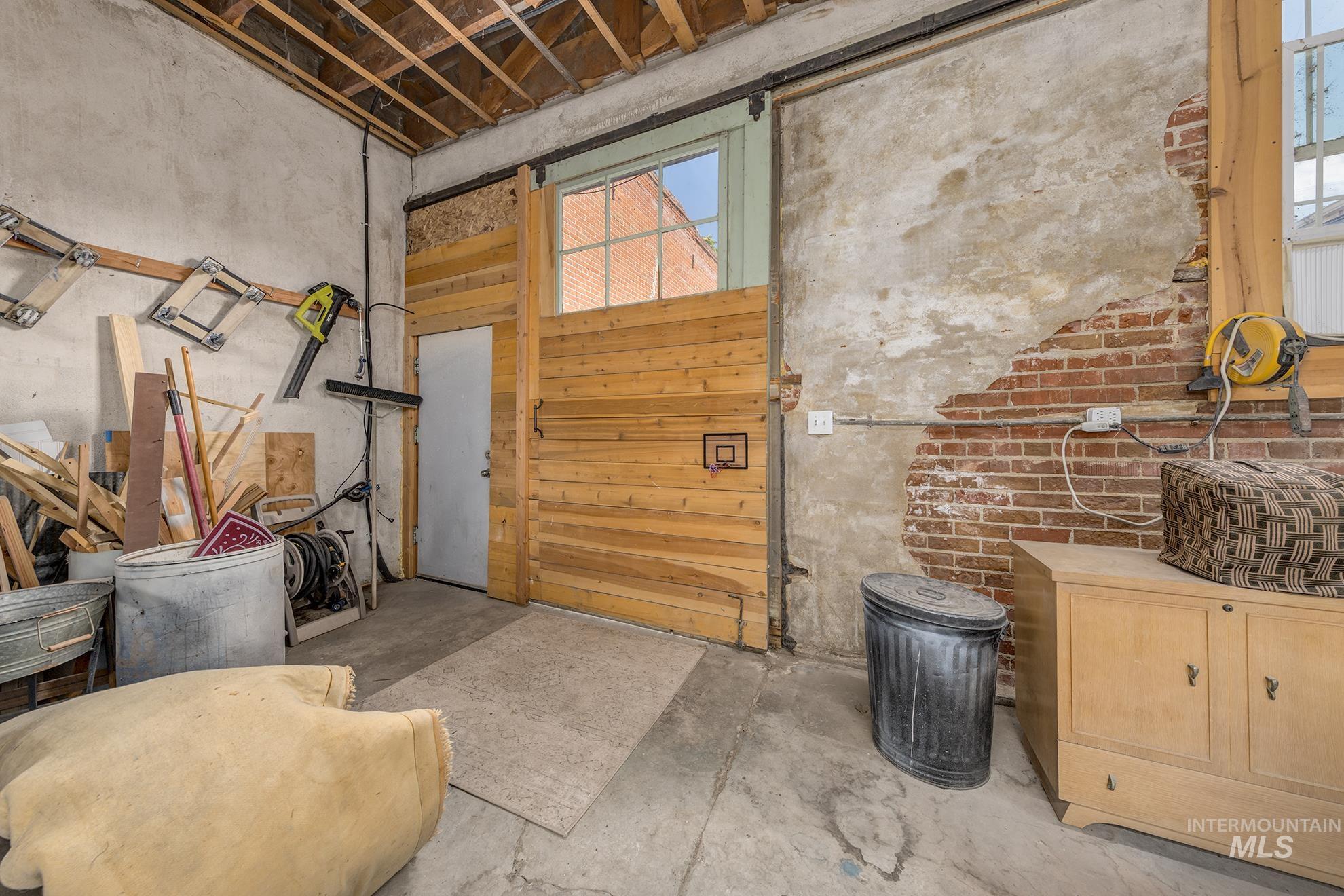 Miscellaneous room with unfinished concrete floors and a sink