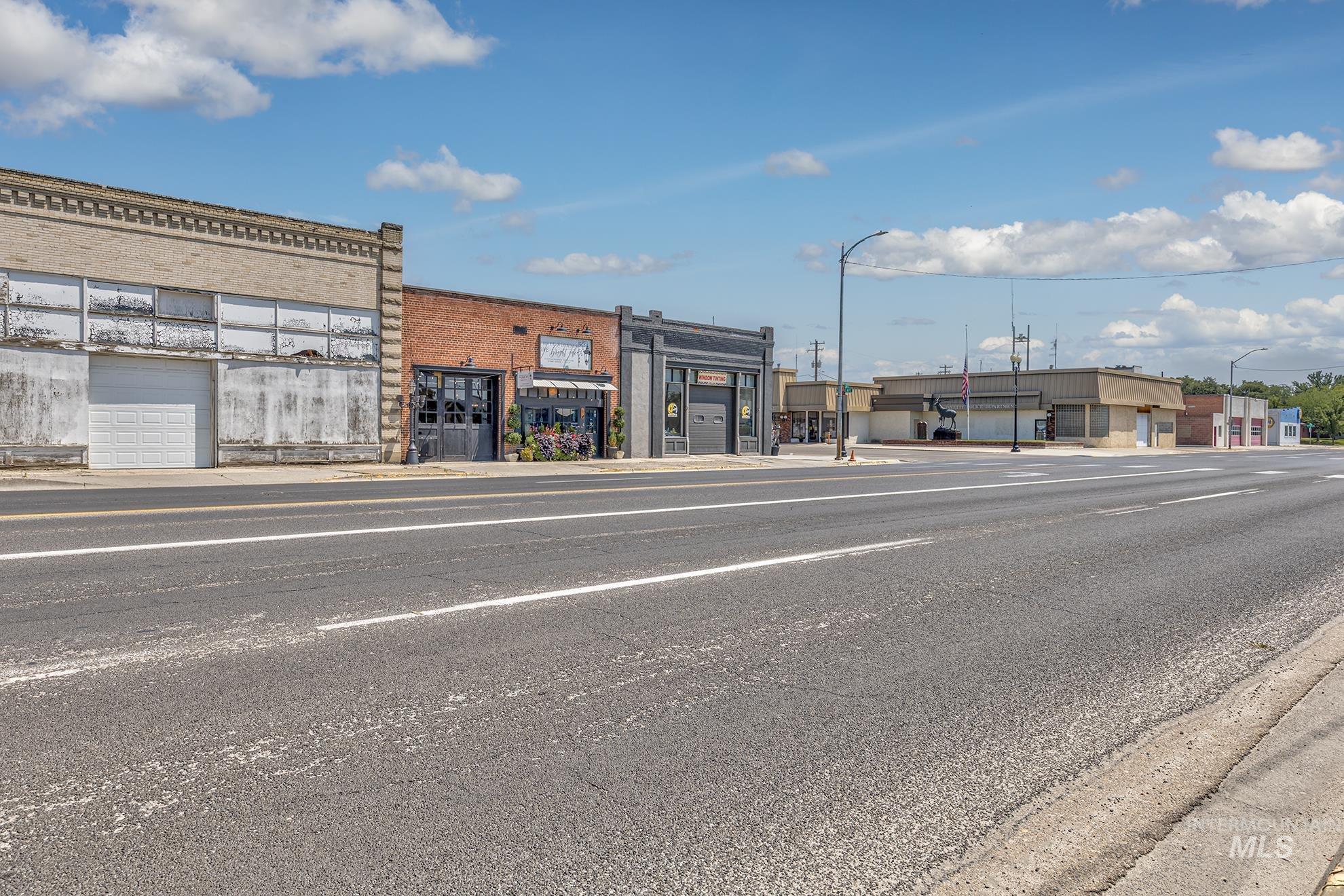 View of asphalt road featuring street lights and sidewalks